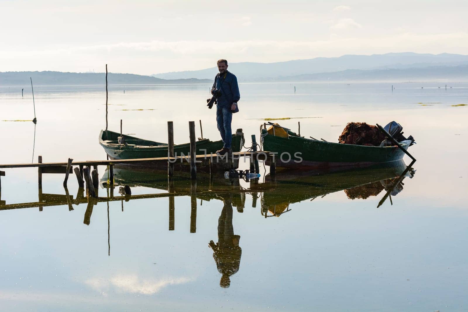 Bruncuteula, Sant'Antioco, Italy - January 28, 2016: Fishermen with their ancient boats, fall at dawn, landscape of the lagoon of Sant'Antioco in south west Sardinia.