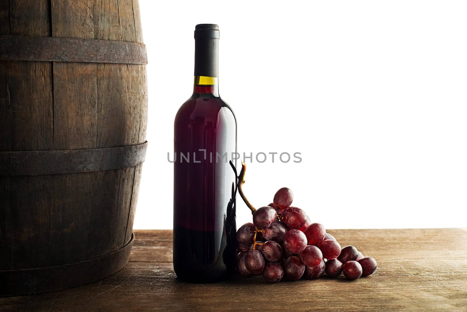 Bottle of red wine with wooden barrel background isolated on white