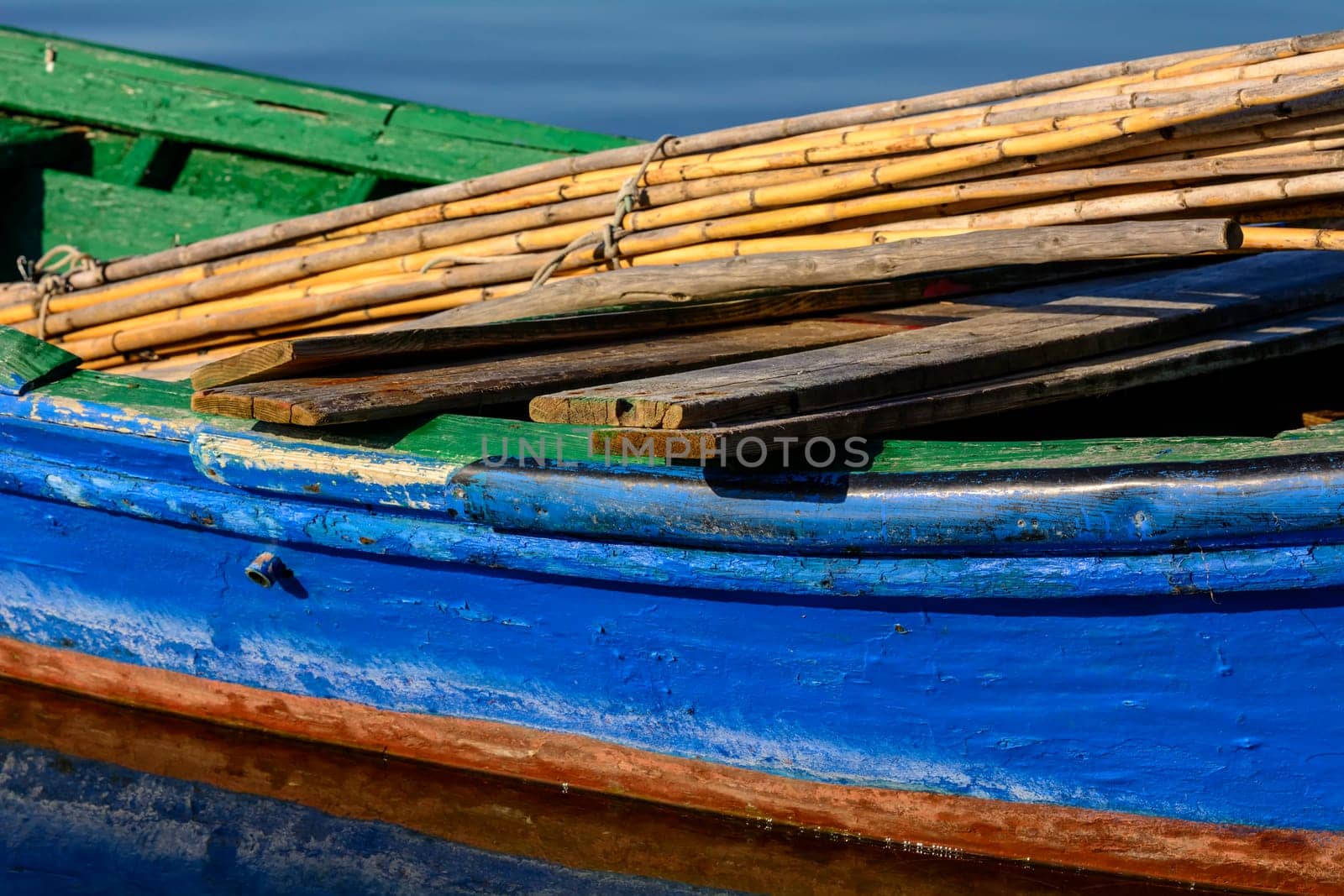 Old wooden fishing boats with bright colors at dawn on the lake. Landscape of lagoon in Sardinia south west.