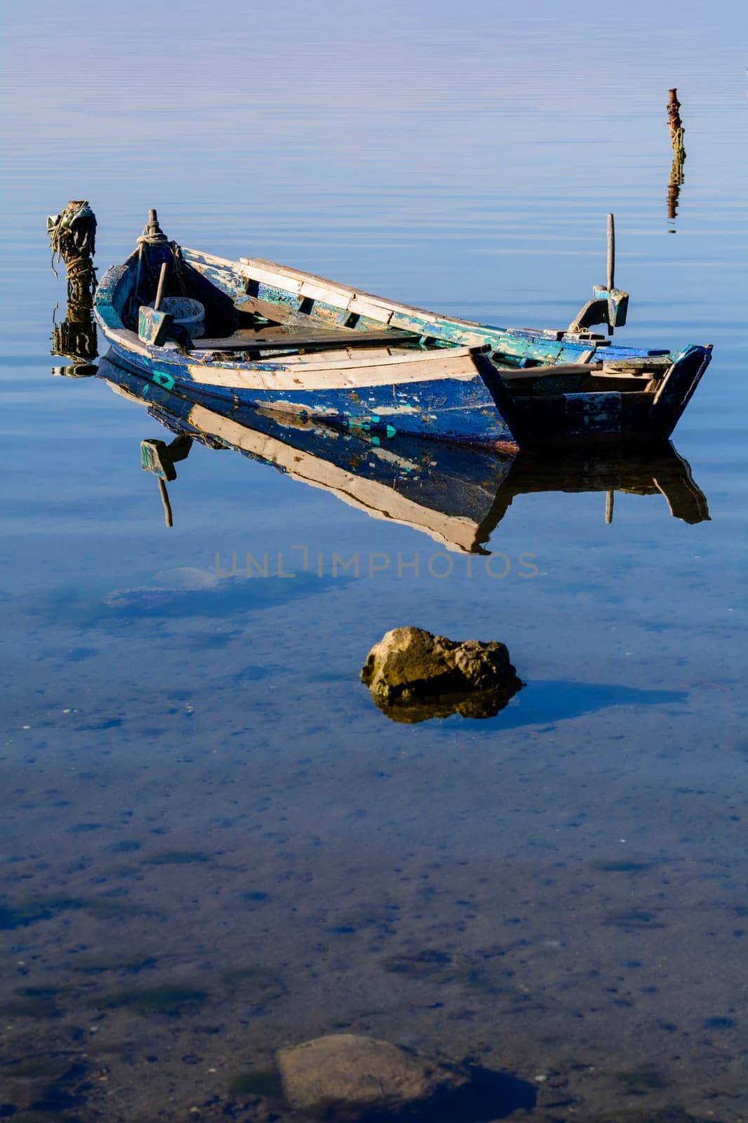 Old wooden fishing boats with bright colors at dawn on the lake. Landscape of lagoon in Sardinia south west.