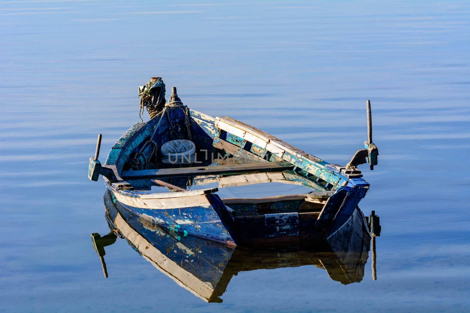 Old wooden fishing boats with bright colors at dawn on the lake. Landscape of lagoon in Sardinia south west.