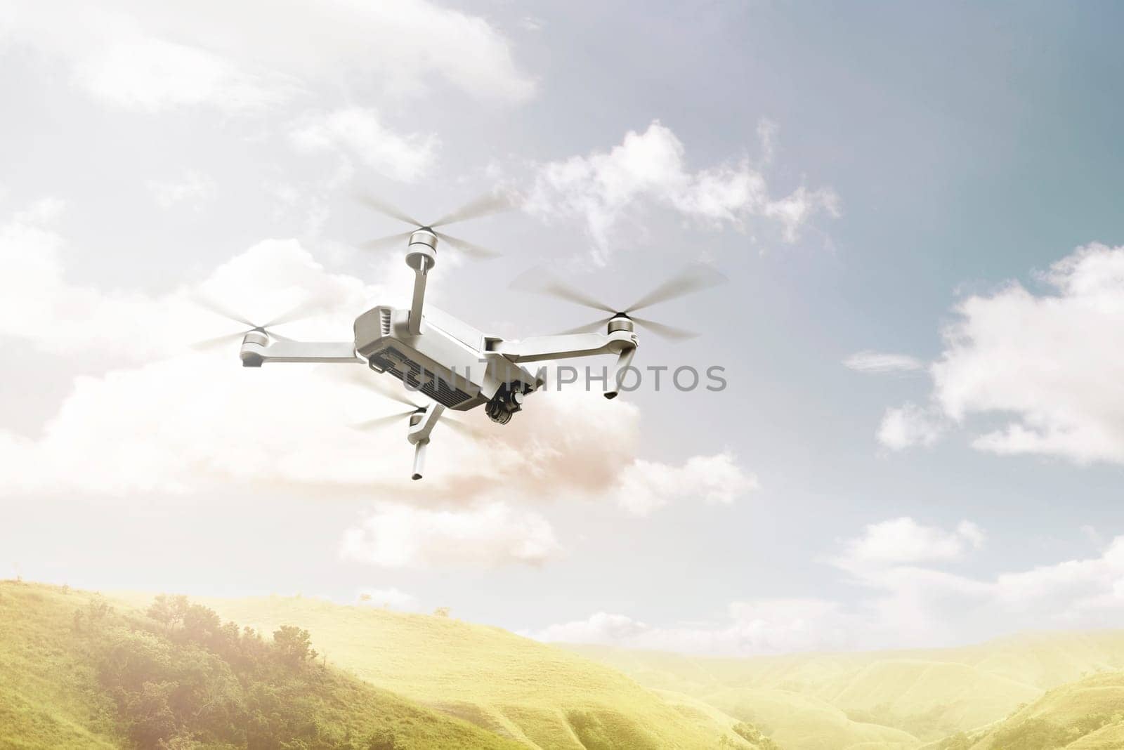 White drone with camera flying above green hills with blue sky background