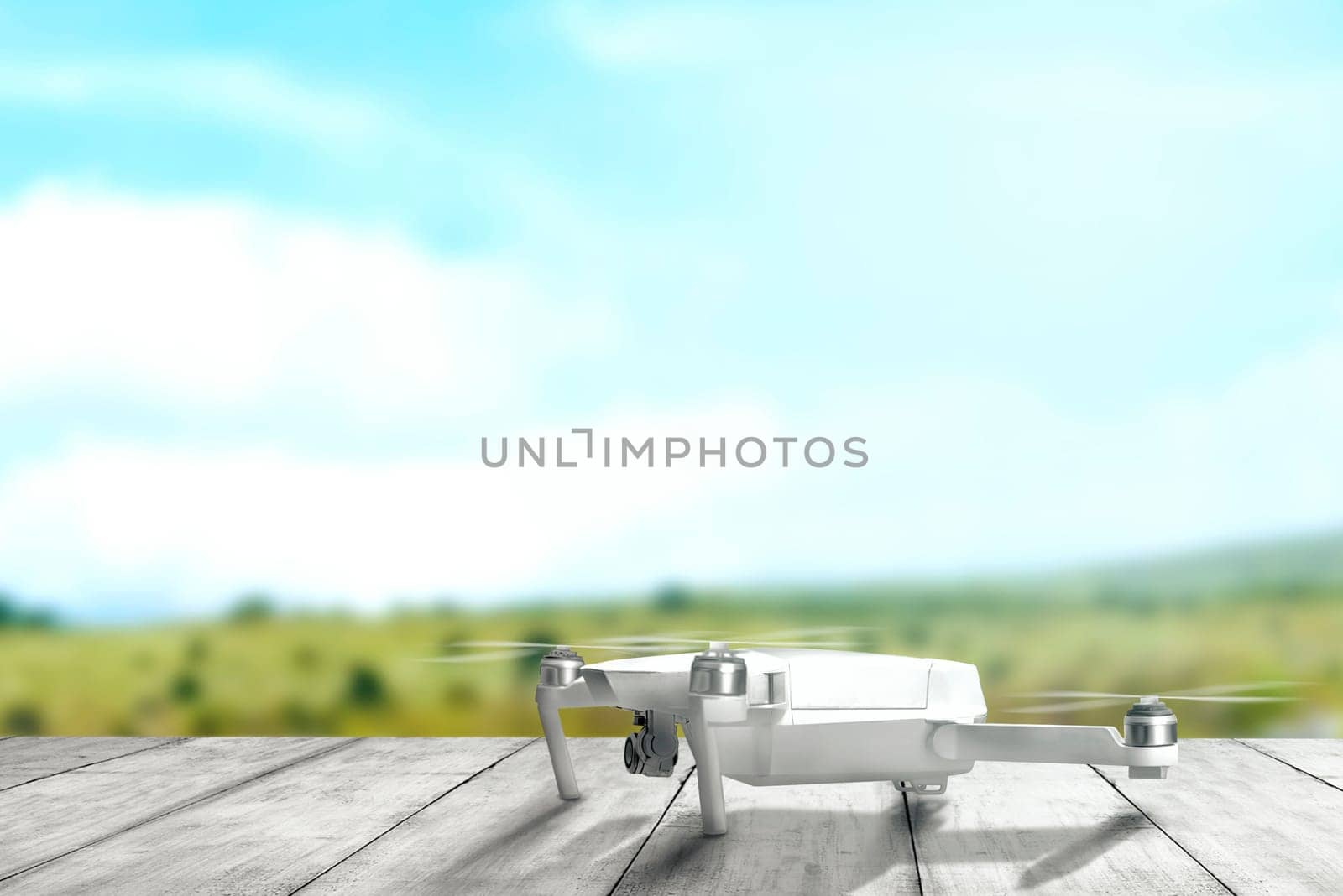 White drone with camera on wooden table ready to flying to the air with blurry landscapes background