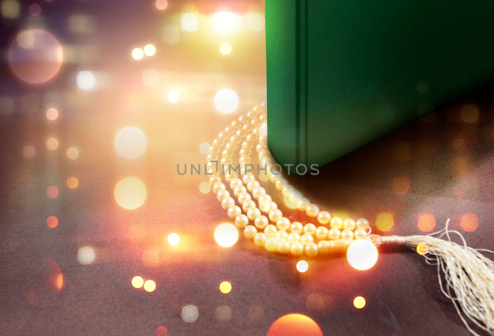 Quran and prayer beads on the table with blurry lights background
