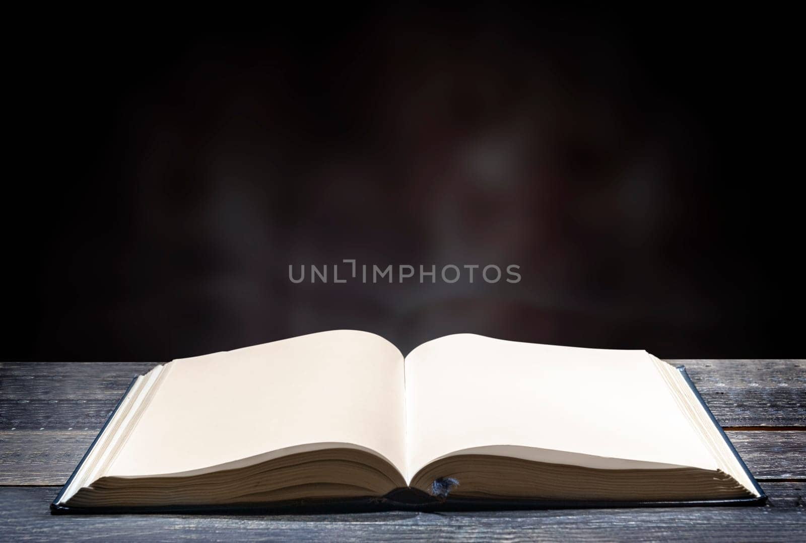 Quran open on wooden table over blurry background