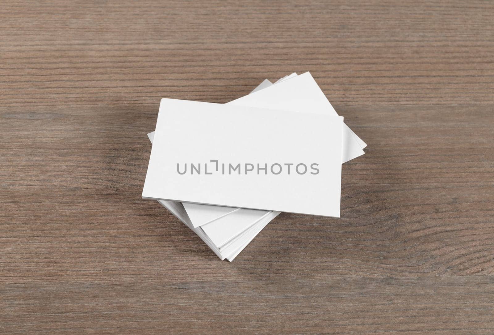 Mockup of blank business cards on wood table background.