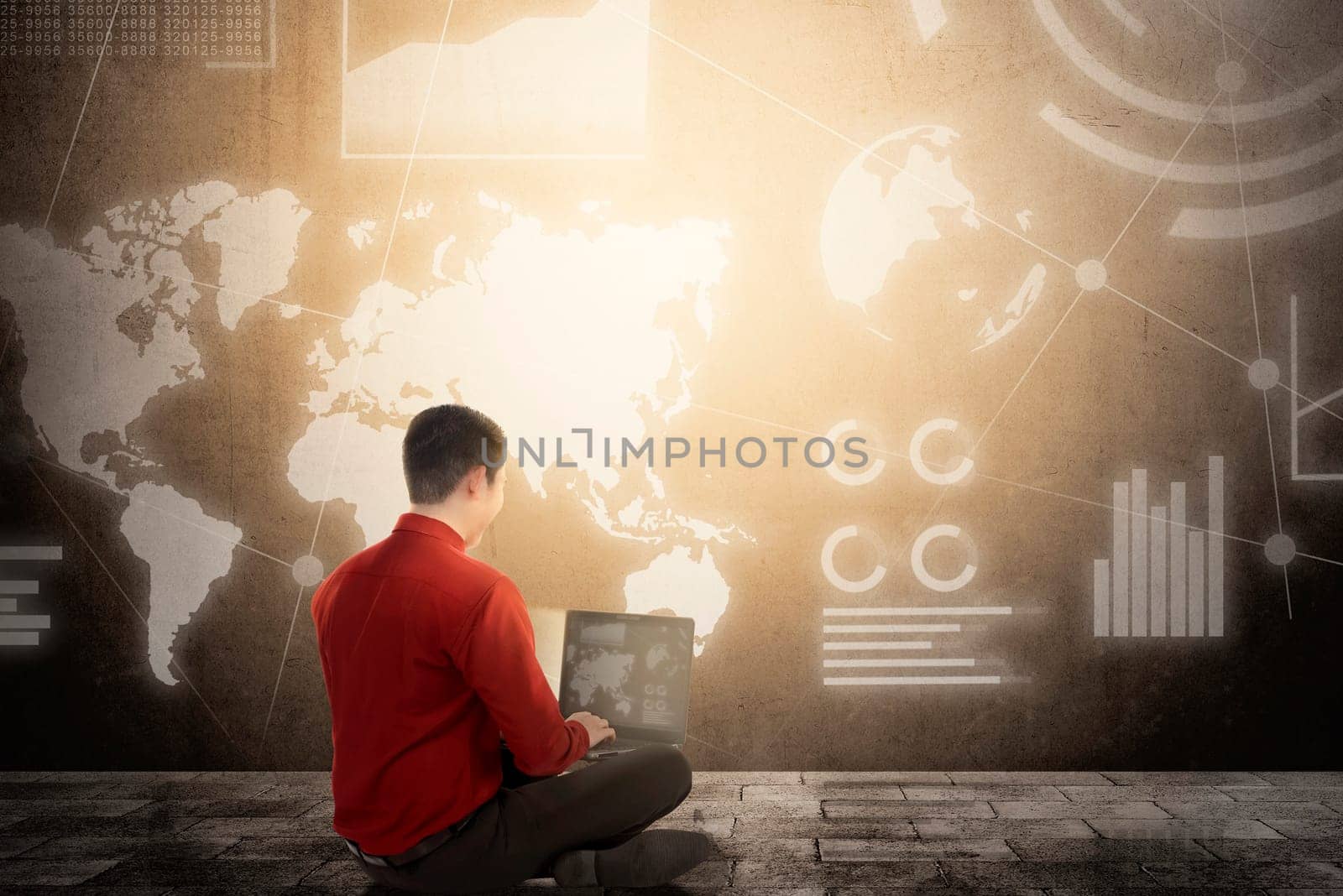 Rear view of asian businessman sitting and using laptop with virtual screen which display the interface of financial chart and world maps. Digital technology concept