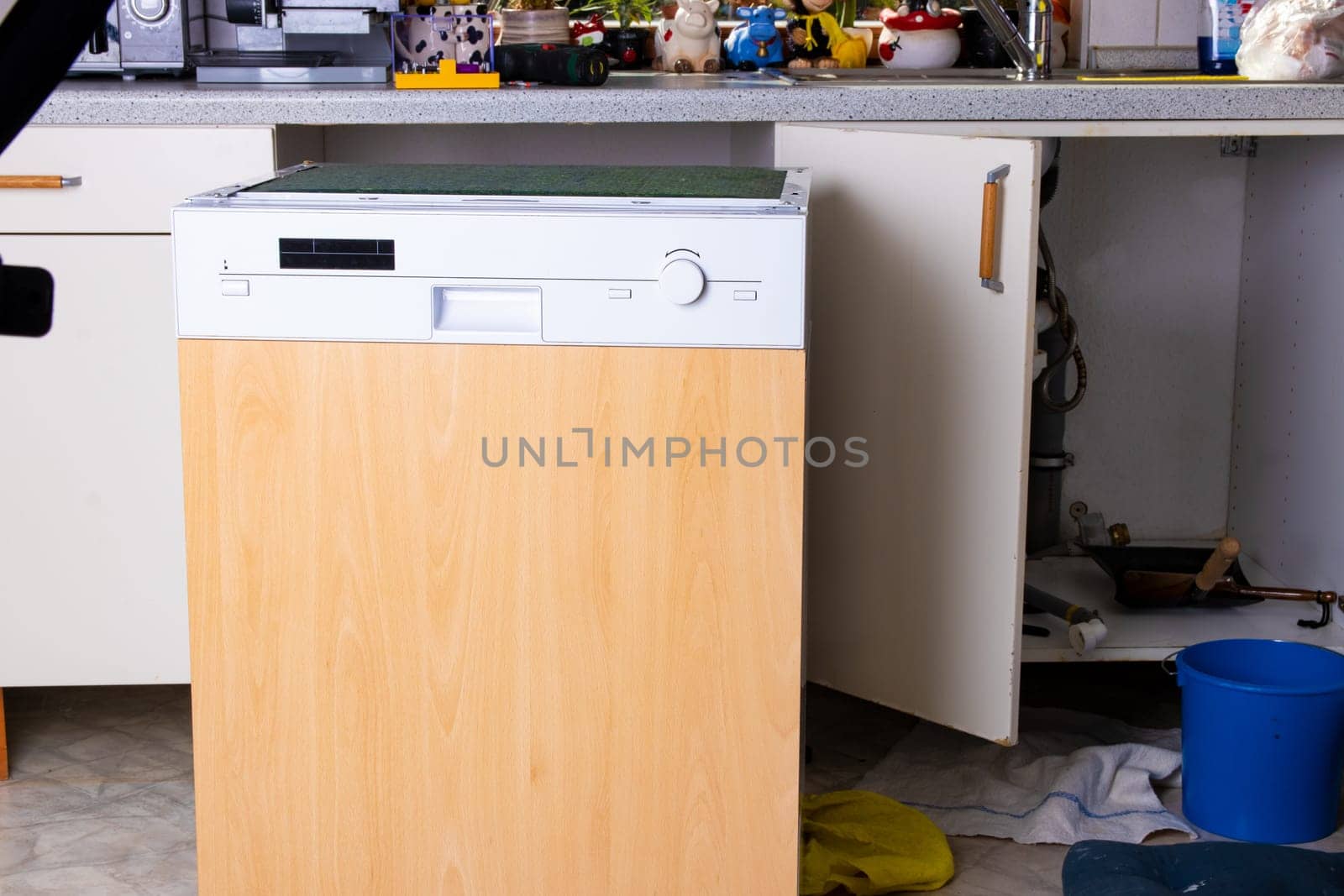 People in technician jobs. A broken built-in dishwasher in a white kitchen was removed from the kitchenette.