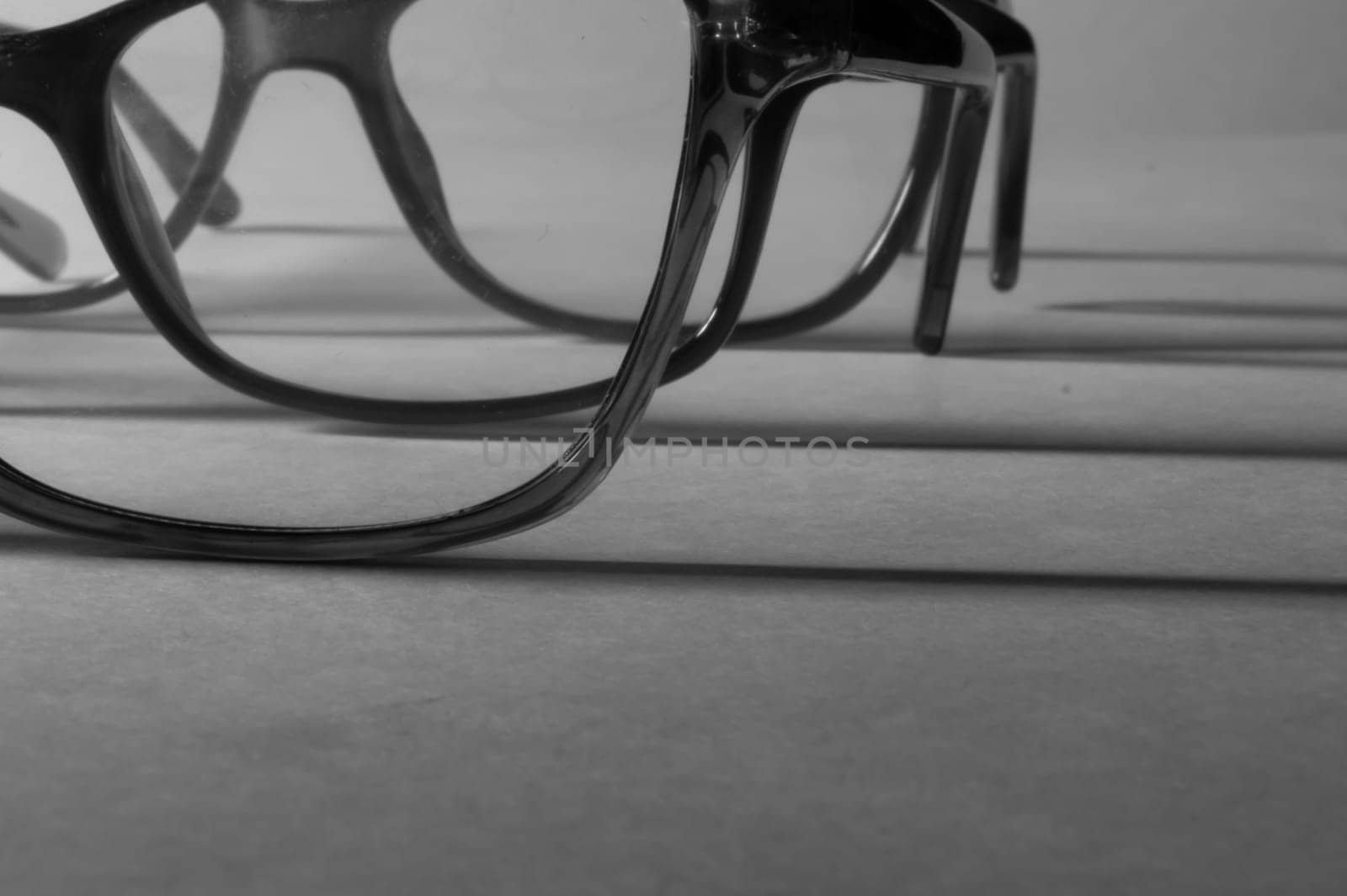 Rimmed eyeglasses closeup on a white background abstract view
