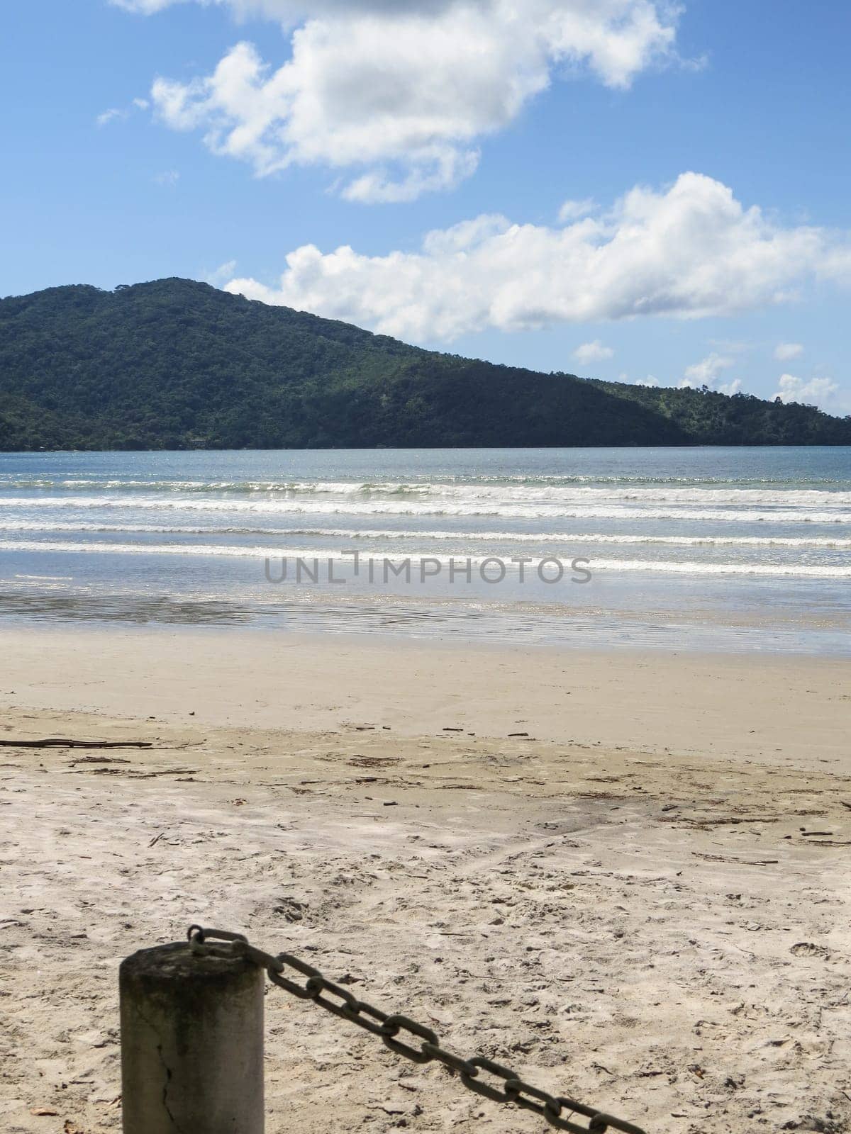 View of seaside in sunny day, with blue sky, and white clouds.