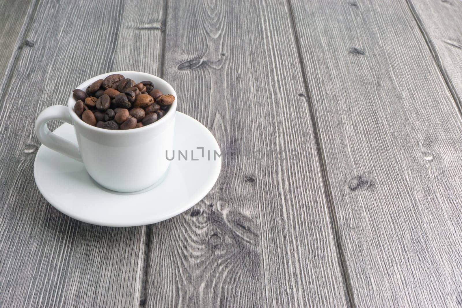 Coffee cup and coffee beans on wooden background. Top view and selective focus