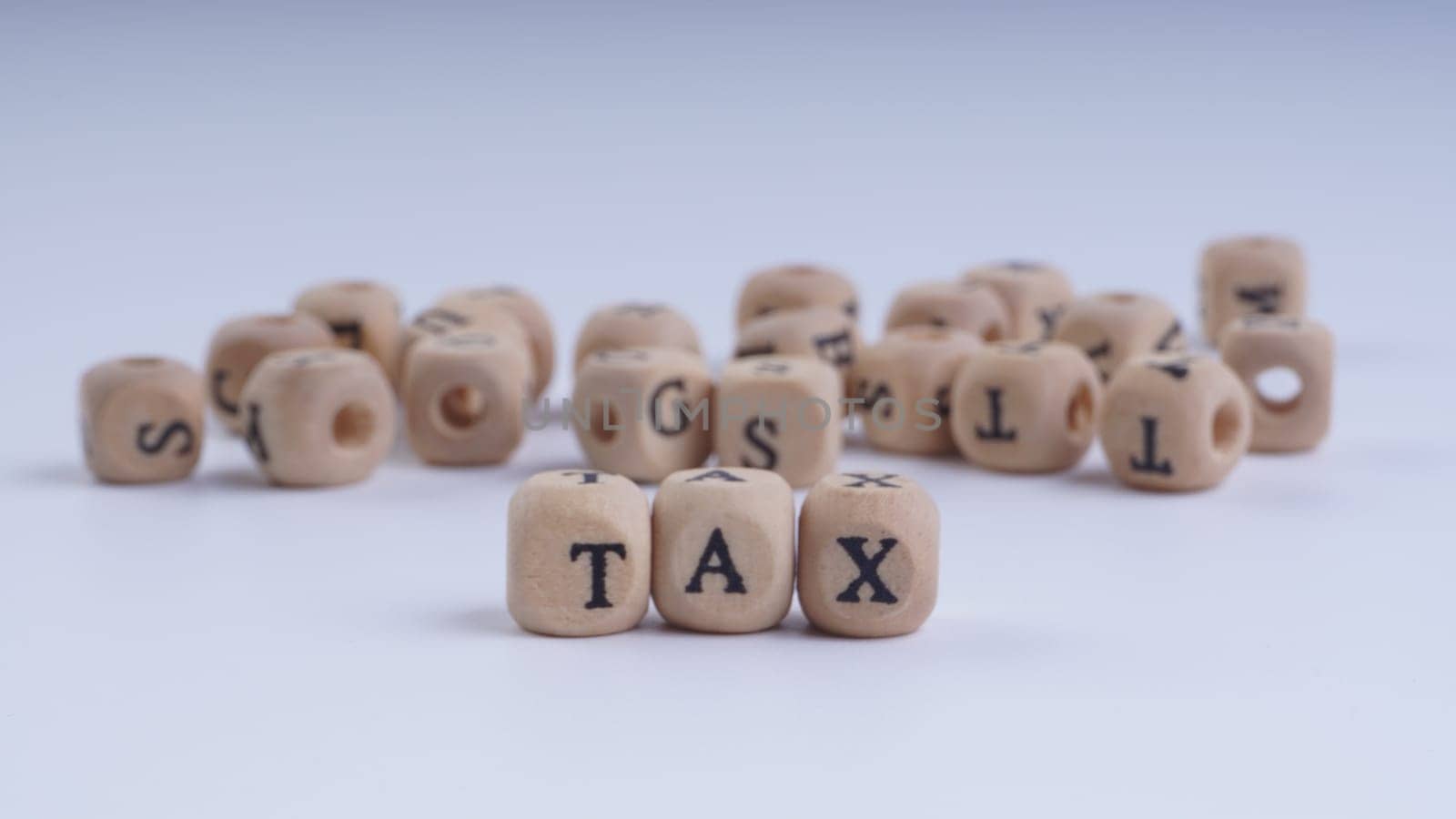 GST inscription on wooden alphabet over white background with selective focus