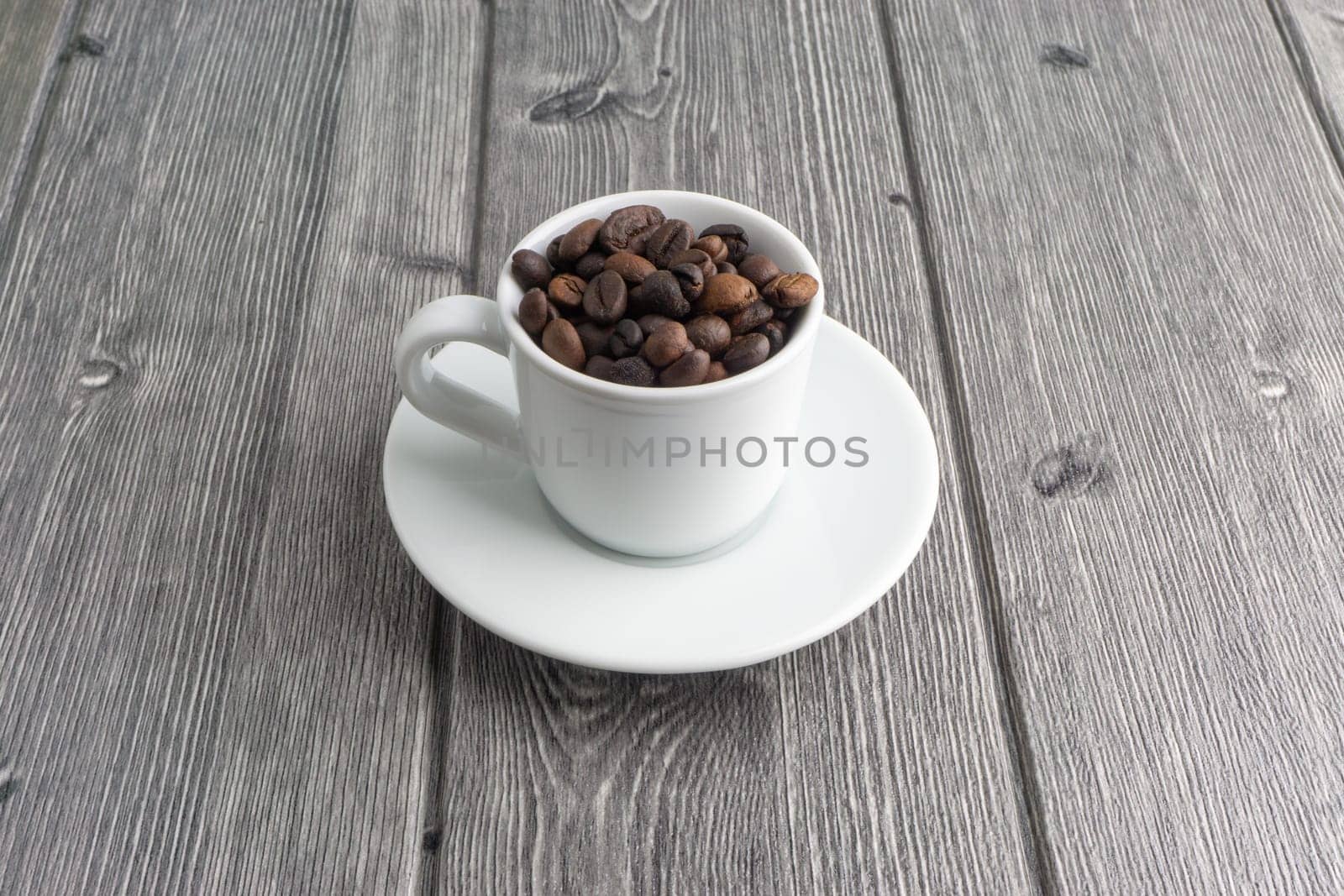 Coffee cup and coffee beans on wooden background. Top view and selective focus