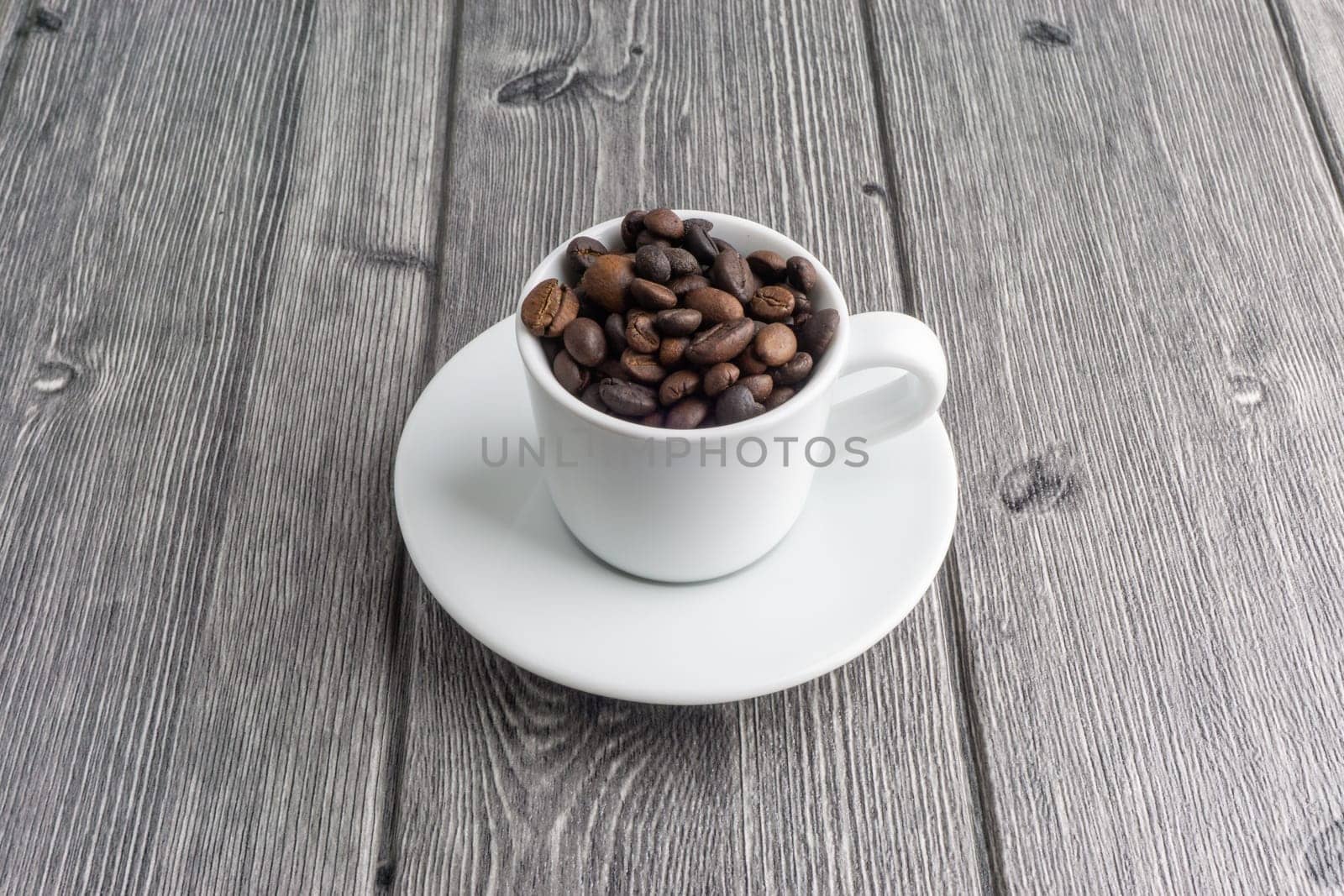 Coffee cup and coffee beans on wooden background. Top view and selective focus