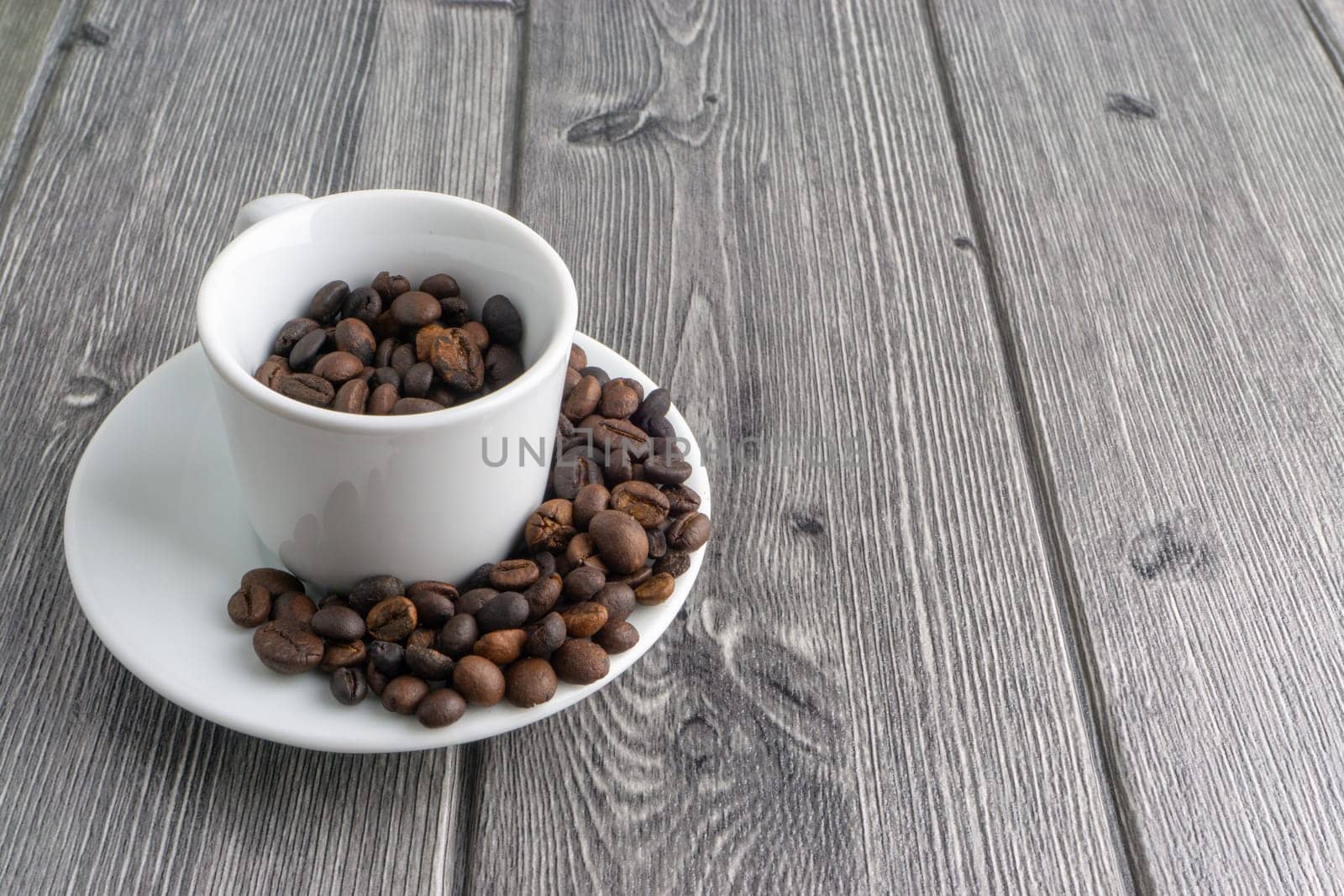 Coffee cup and coffee beans on wooden background. Top view and selective focus