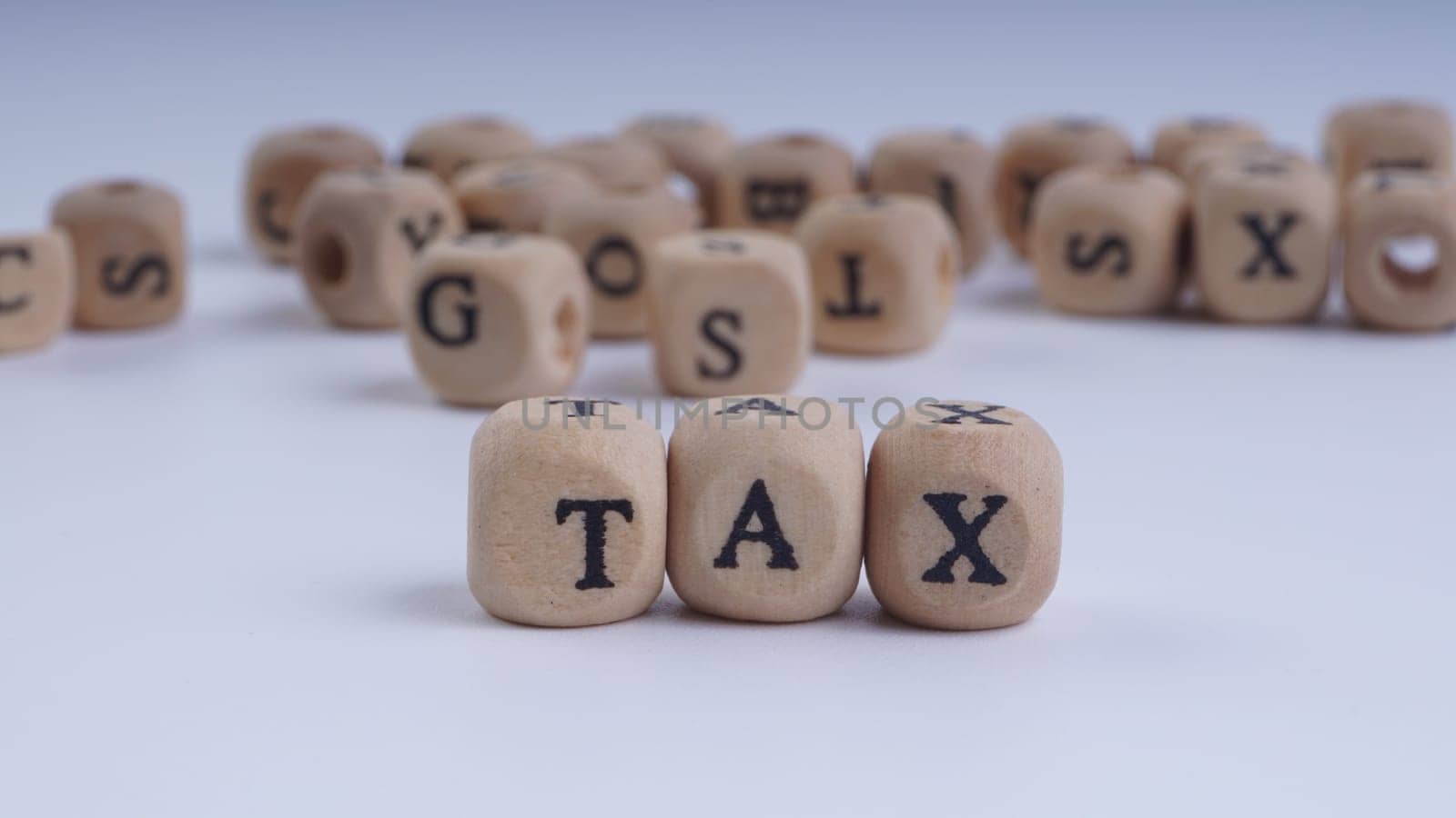 GST inscription on wooden alphabet over white background with selective focus