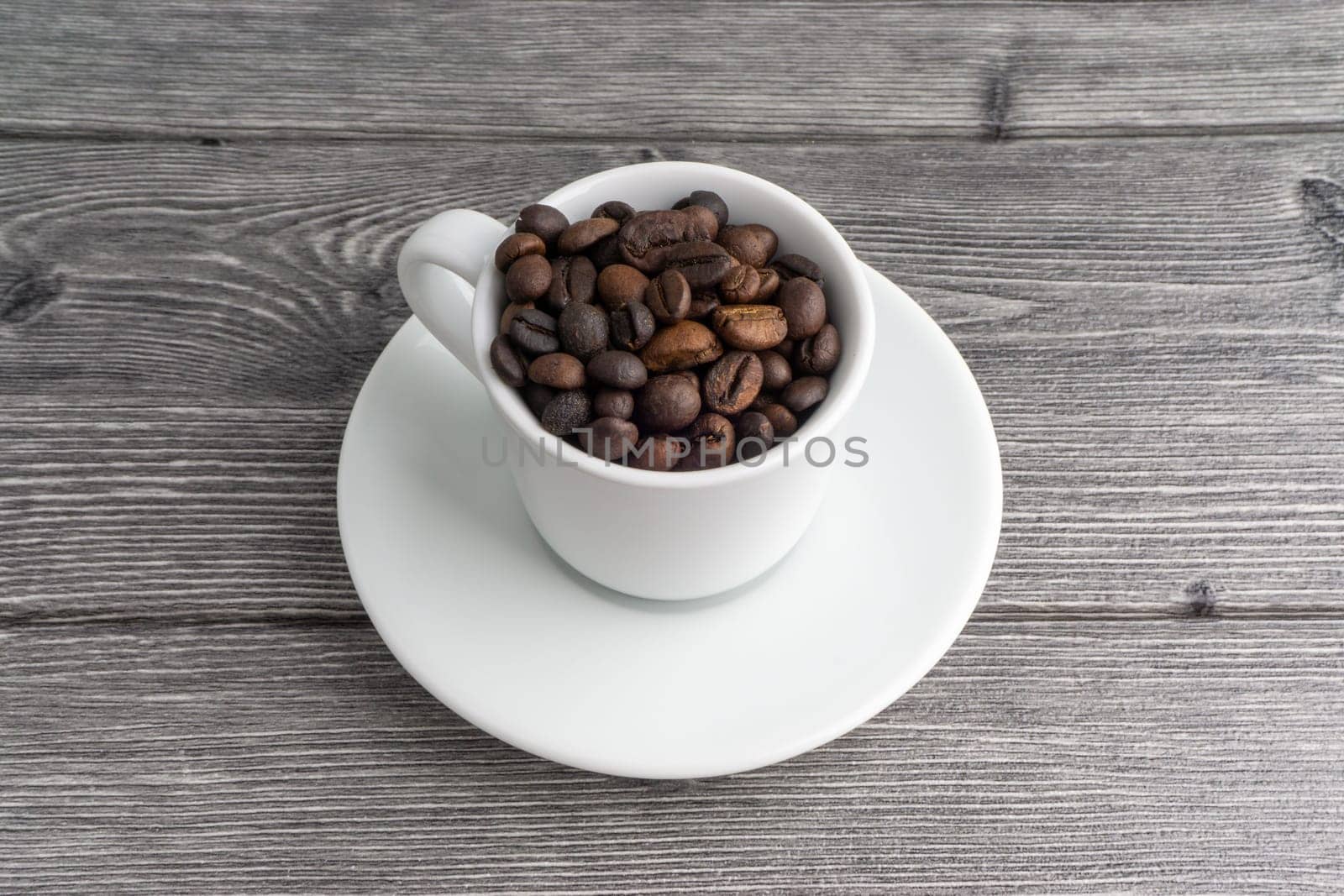 Coffee cup and coffee beans on wooden background. Top view and selective focus