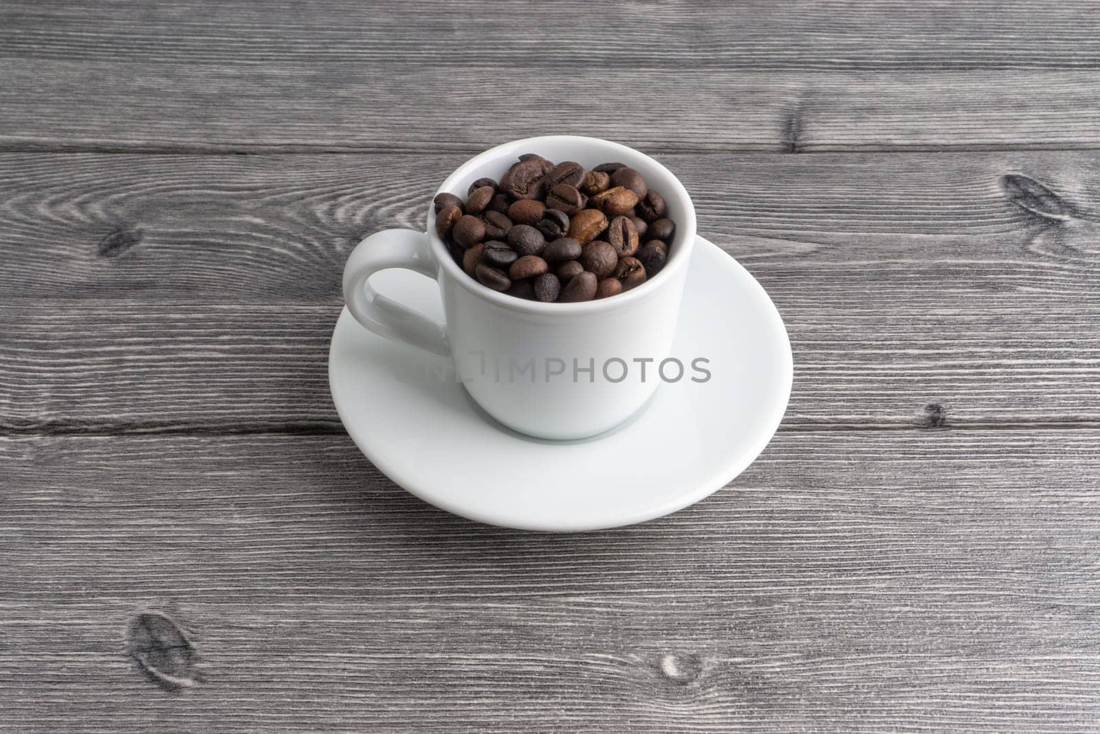 Coffee cup and coffee beans on wooden background. Top view and selective focus