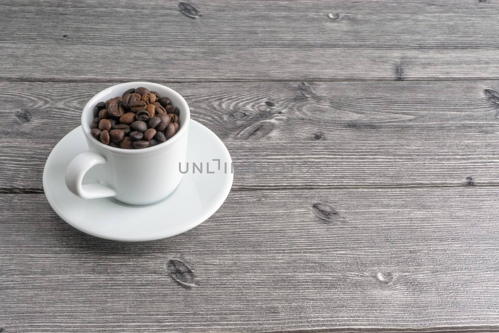 Coffee cup and coffee beans on wooden background. Top view and selective focus
