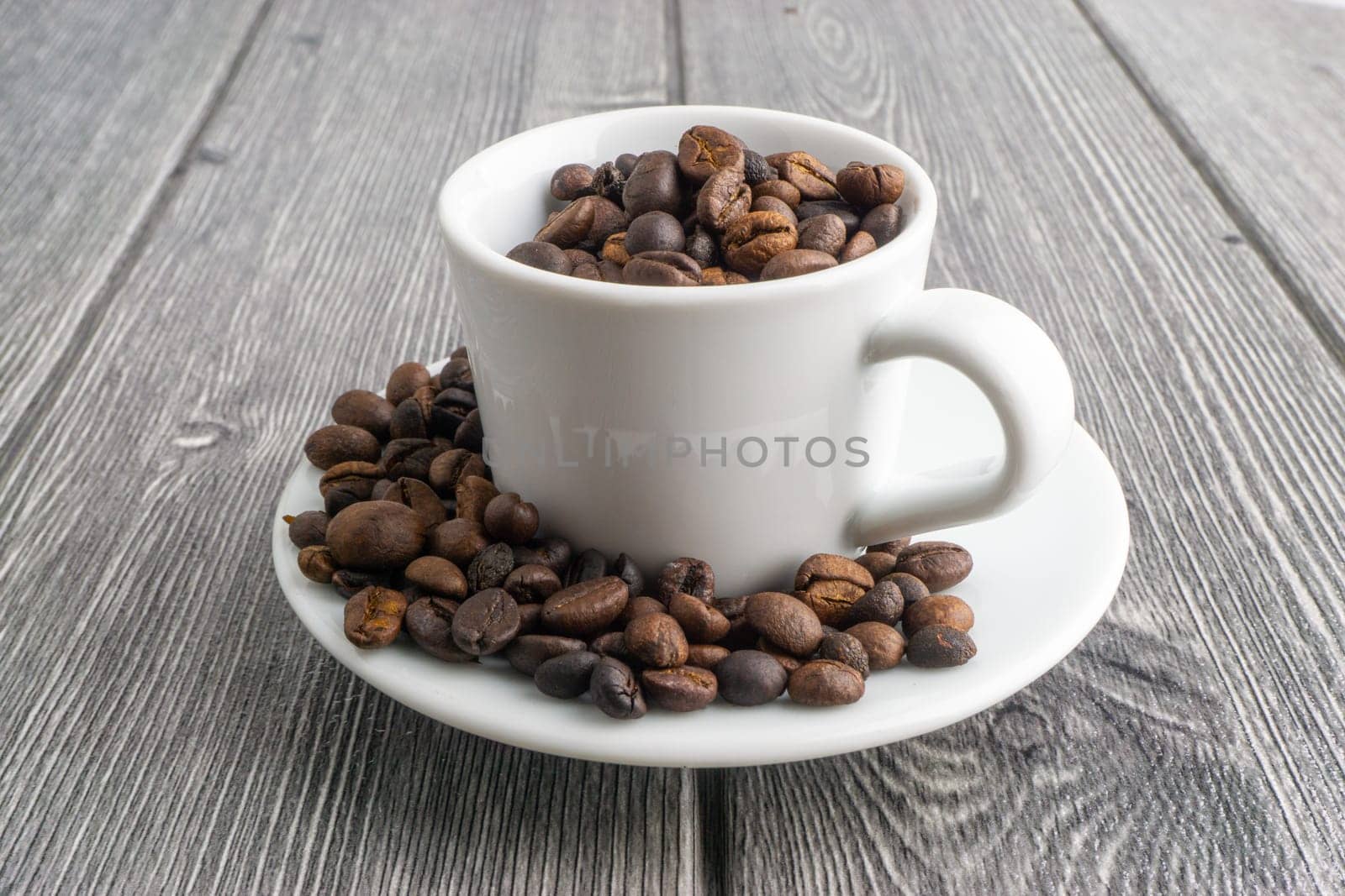 Coffee cup and coffee beans on wooden background. Top view and selective focus