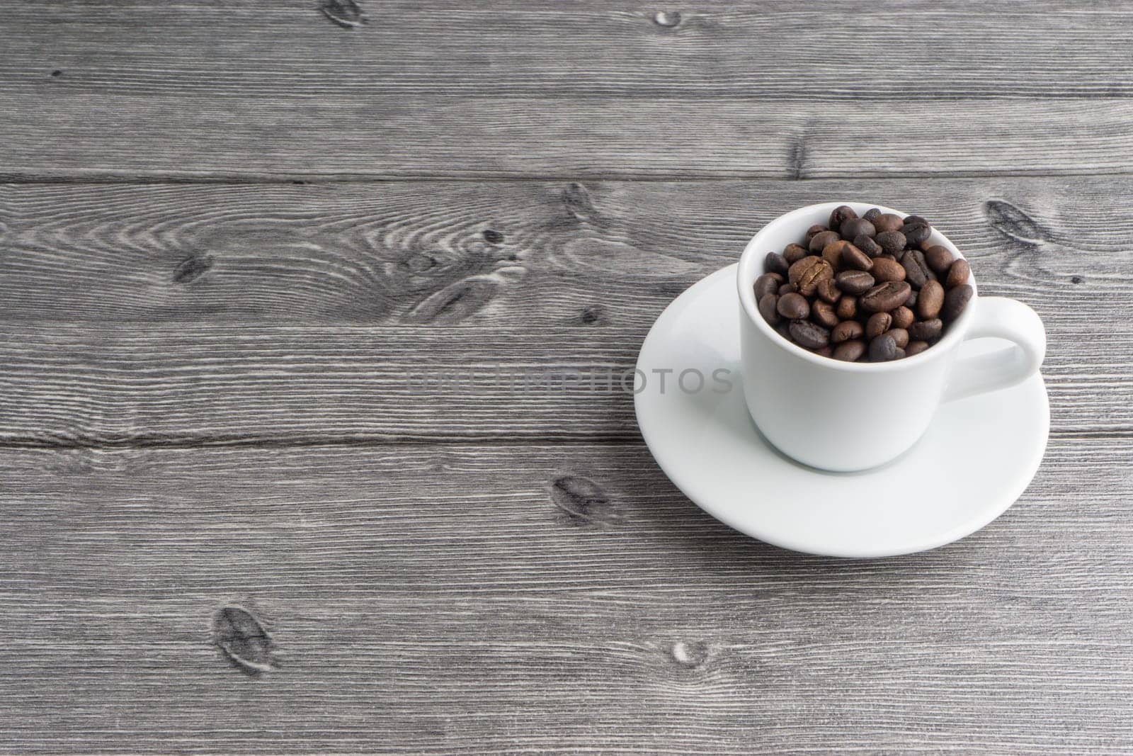 Coffee cup and coffee beans on wooden background. Top view and selective focus