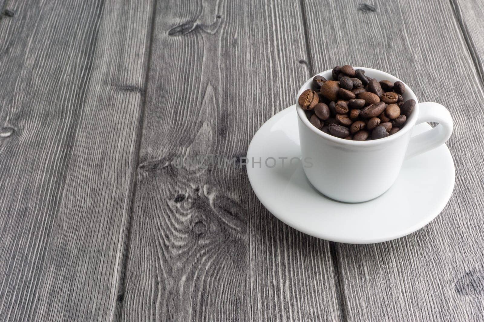 Coffee cup and coffee beans on wooden background. Top view and selective focus