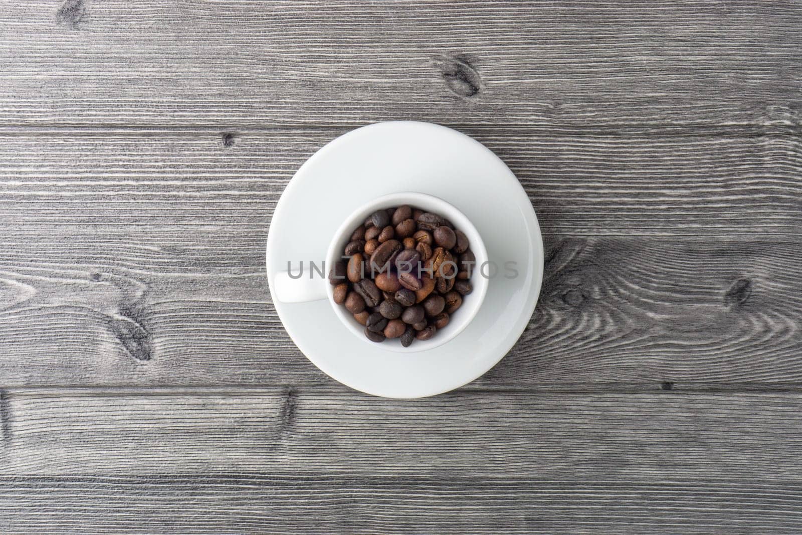 Coffee cup and coffee beans on wooden background. Top view and selective focus