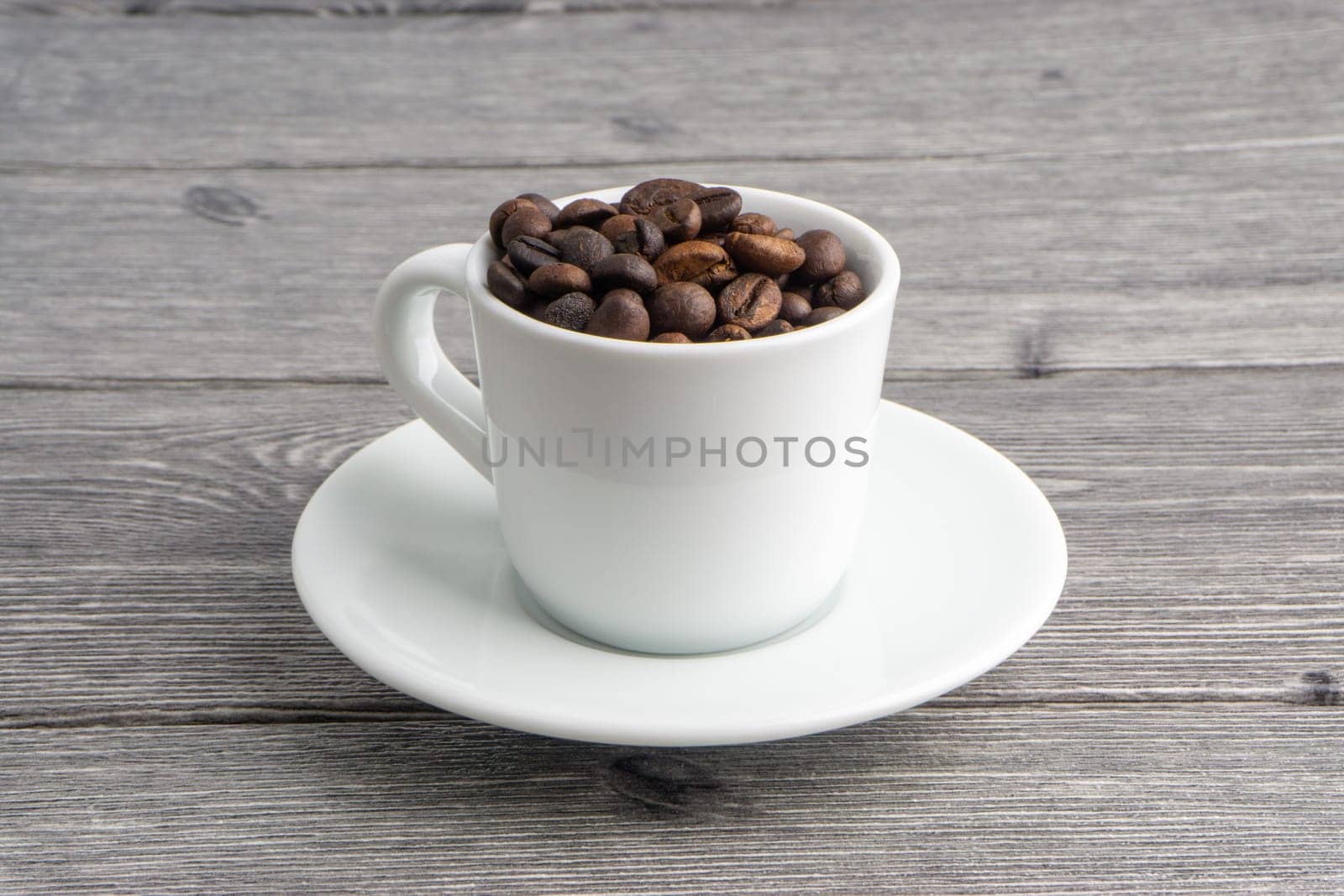 Coffee cup and coffee beans on wooden background. Top view and selective focus