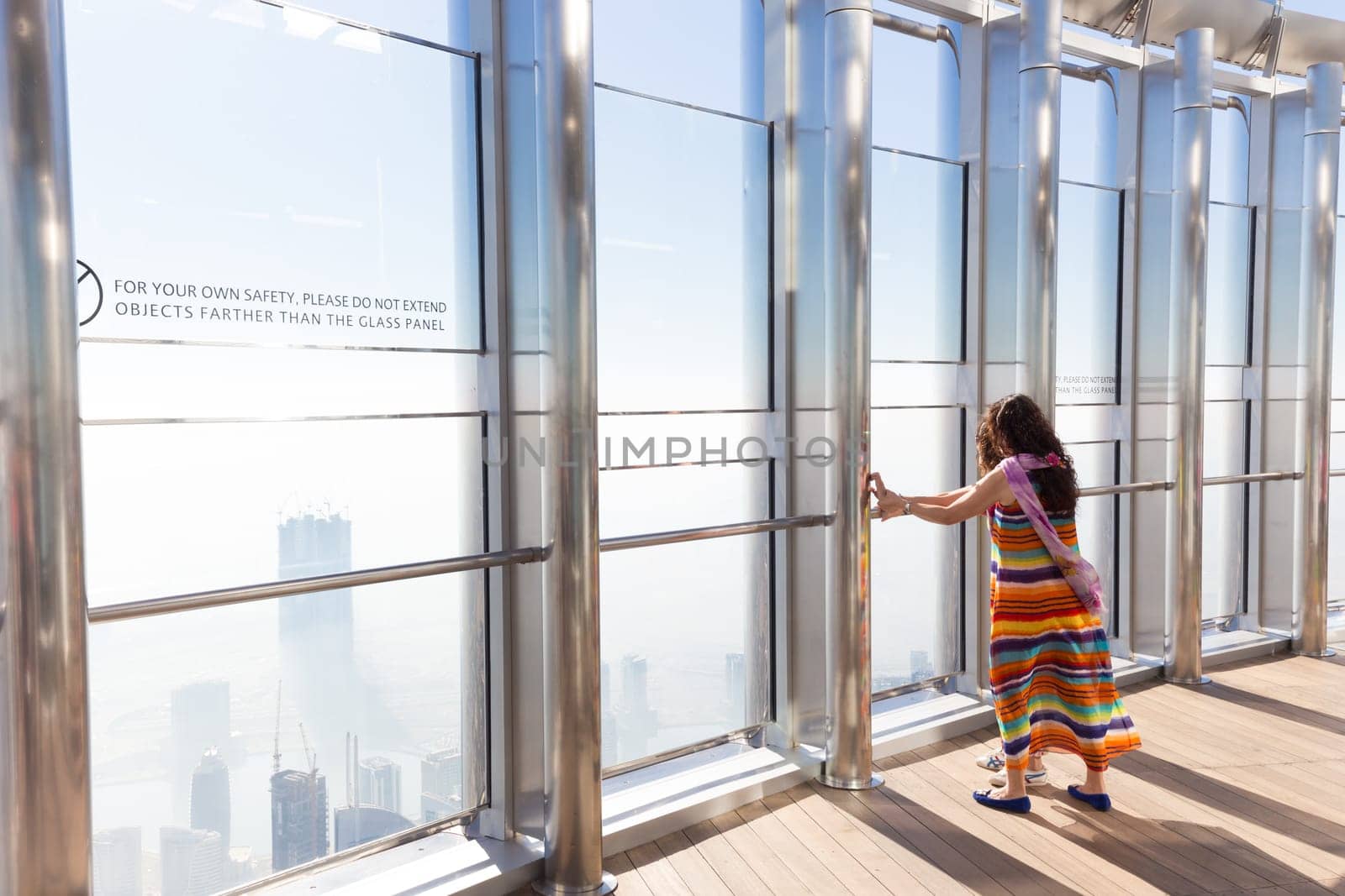 Dubai, UAE - Feb 21, 2016: Tourists having fear of heigh at the top the observation deck of the highest building in the world,Burj Khalifa in Dubai, UAE on 21nd of February, 2016.