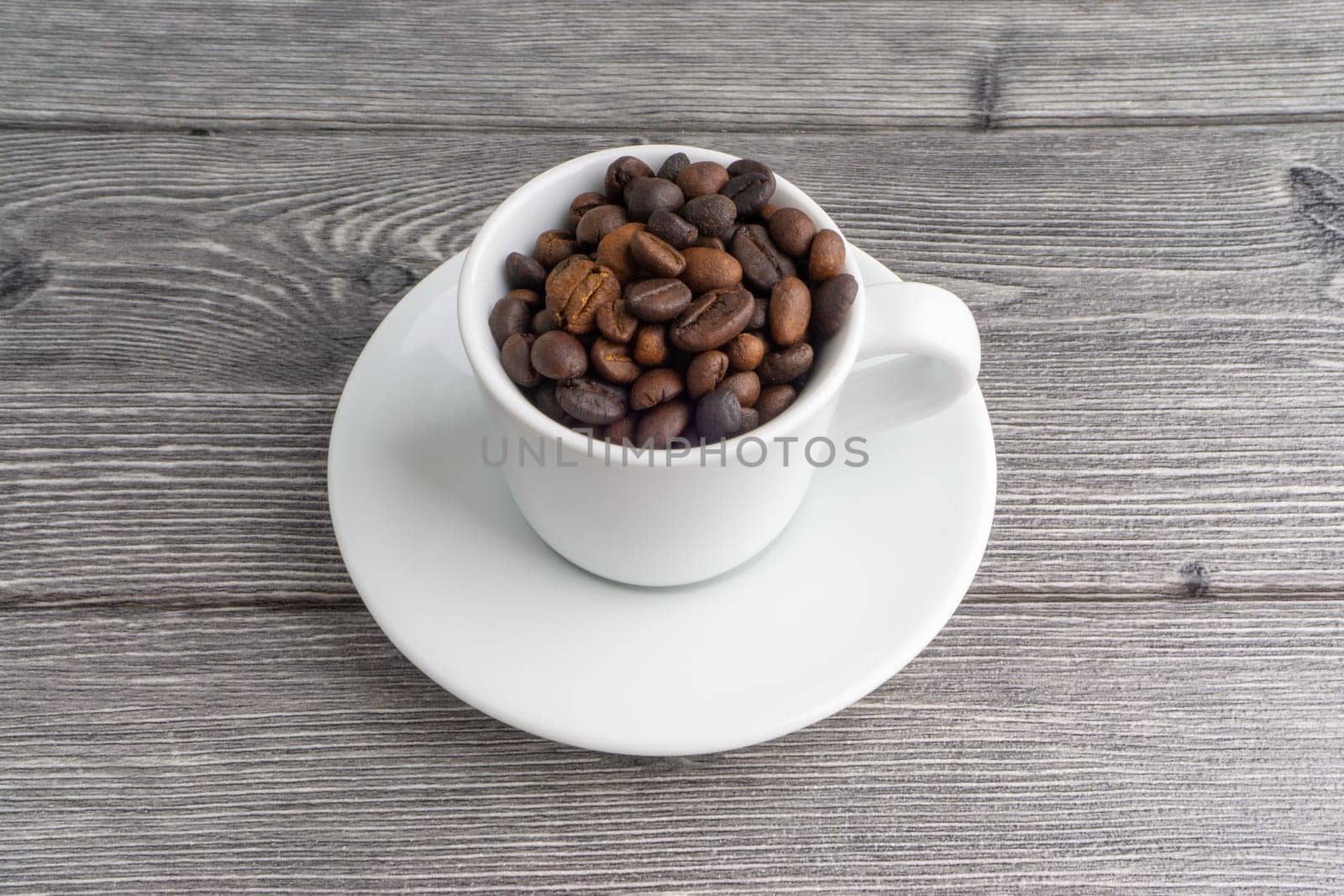 Coffee cup and coffee beans on wooden background. Top view and selective focus