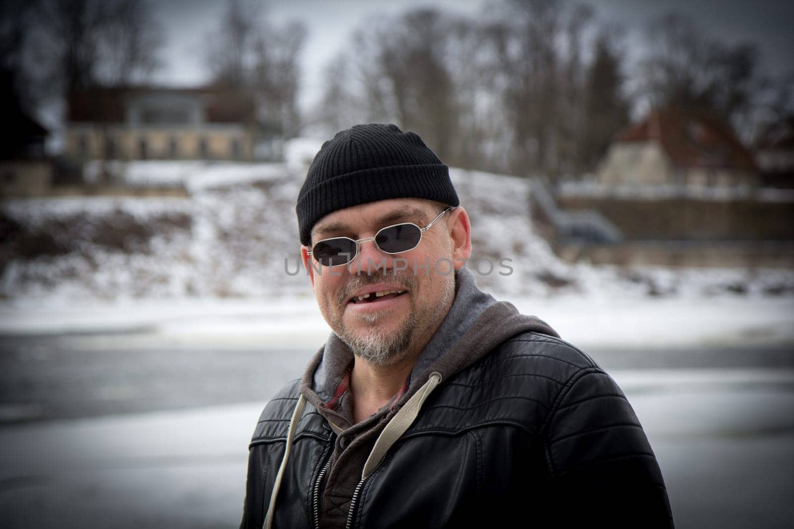 Man with black hat and black sunglasses looking at camera