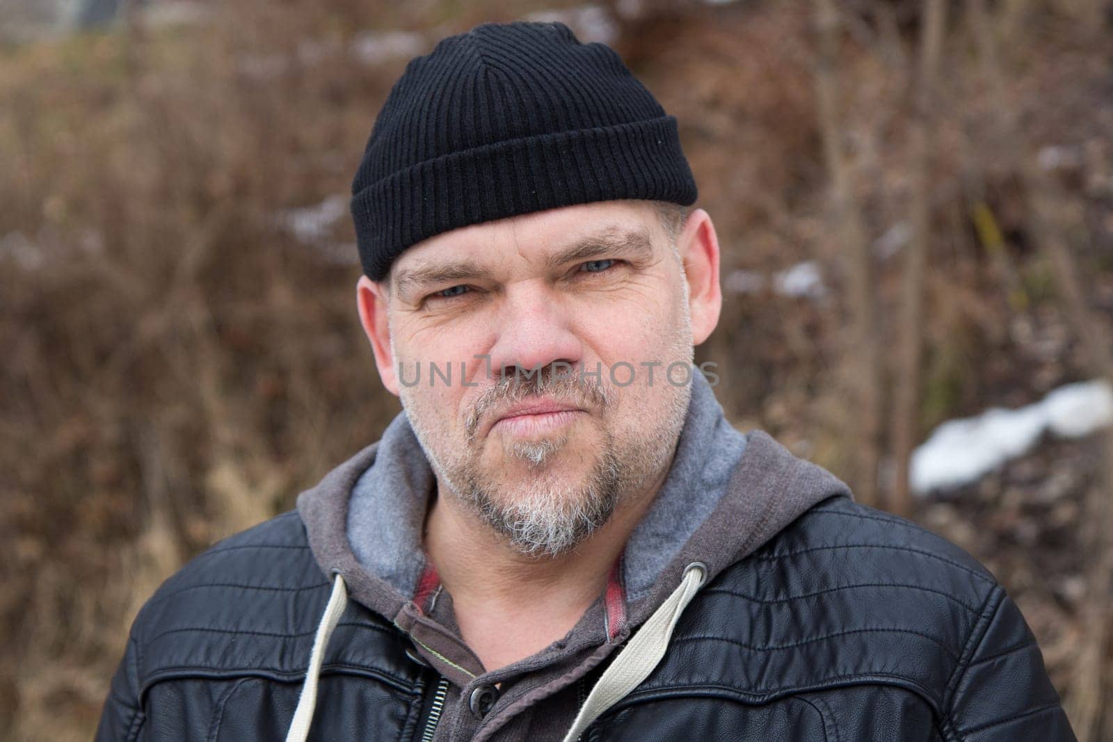 serious man with black hat and beard looking at camera