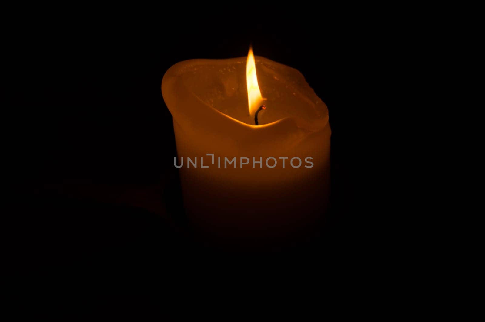 Burning candle in the dark