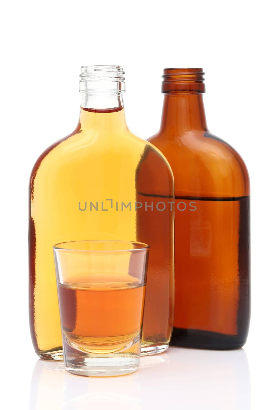 shot glass and pocket bottle of whiskey on white background