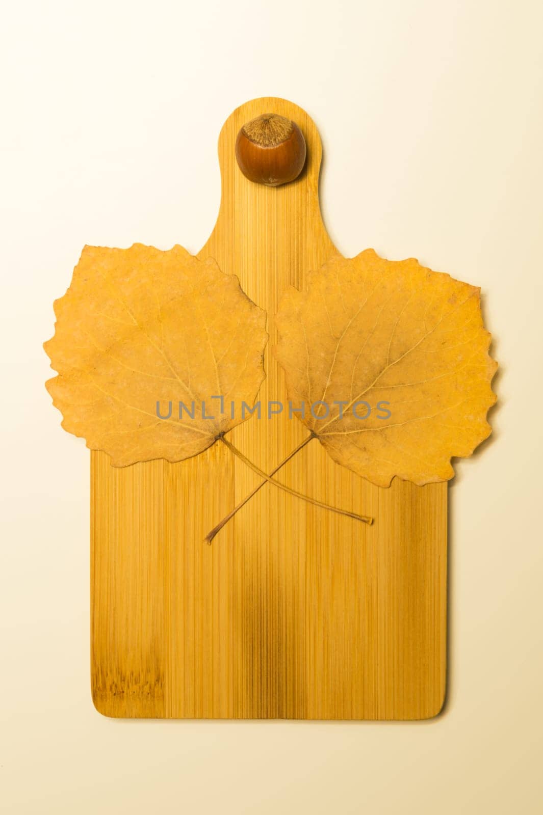 Hazelnut and autumn leaves on a wooden board background