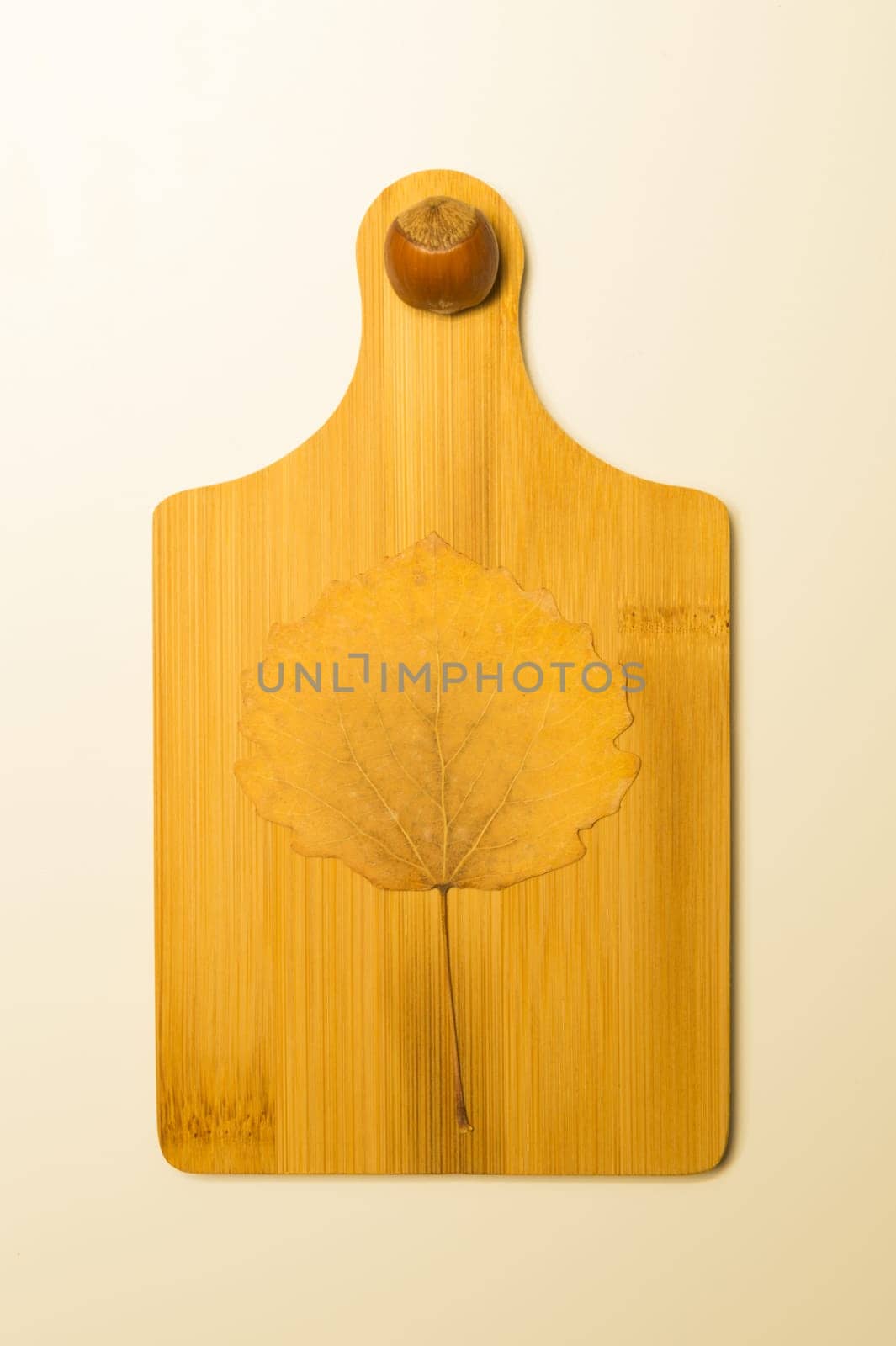 Hazelnut and autumn leaf on a wooden board background