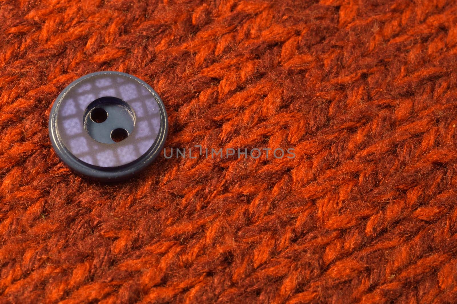 Button on red textile background. macro view. copy space