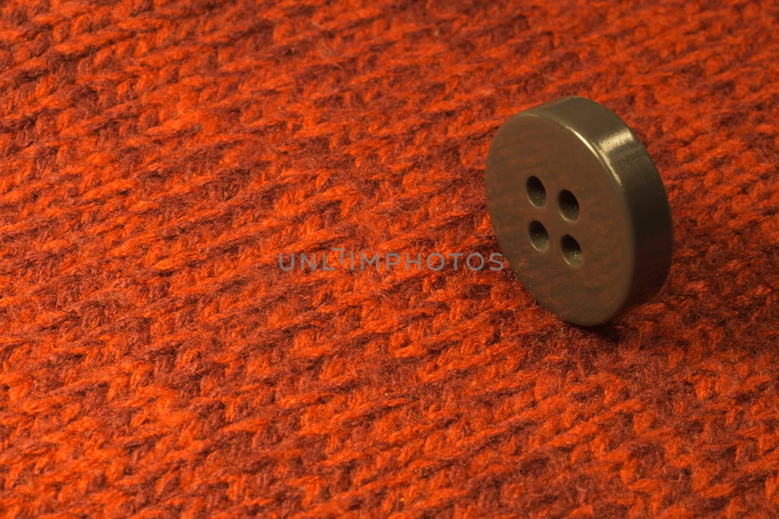 Button on red textile background. macro view. copy space