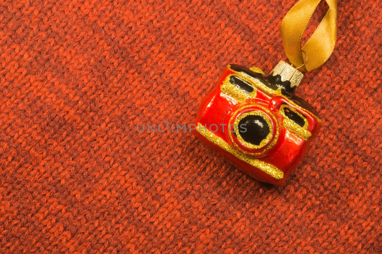 Christmas tree decoration on textile background. Christmas tree toy in a form of a camera. copy space