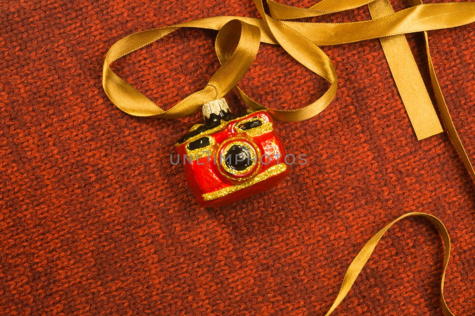 Christmas tree decoration on textile background. Christmas tree toy in a form of a camera. copy space