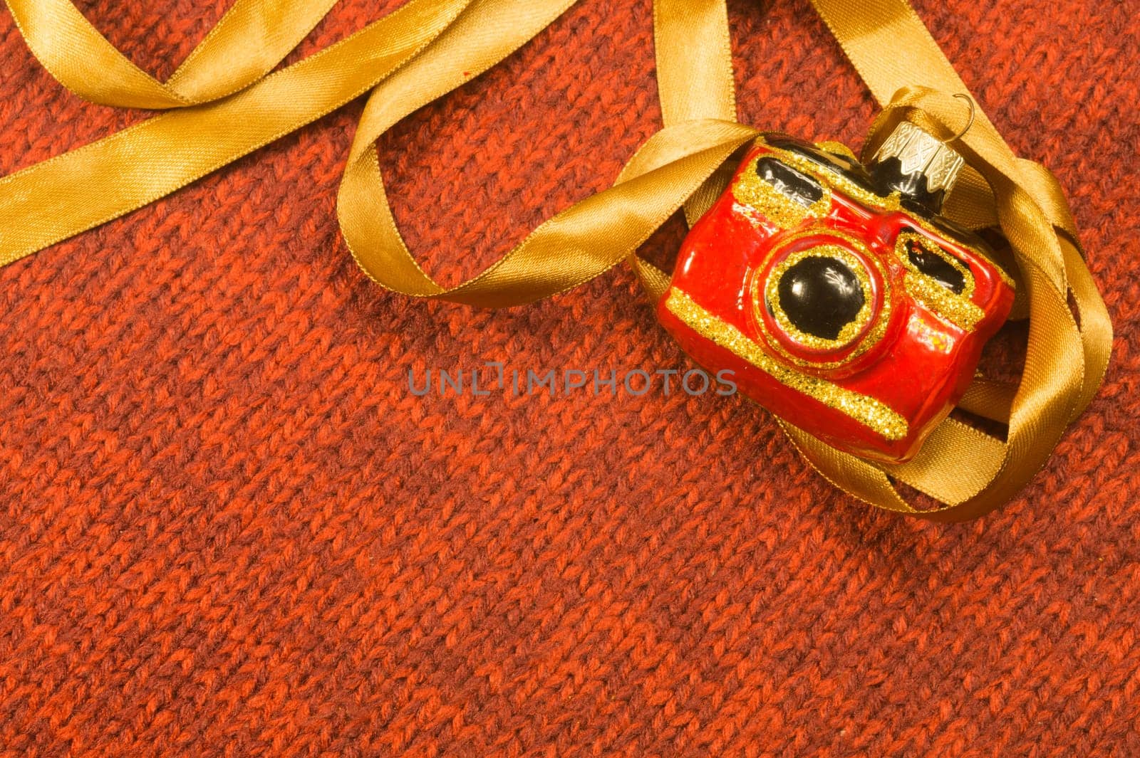 Christmas tree decoration on textile background. Christmas tree toy in a form of a camera. copy space