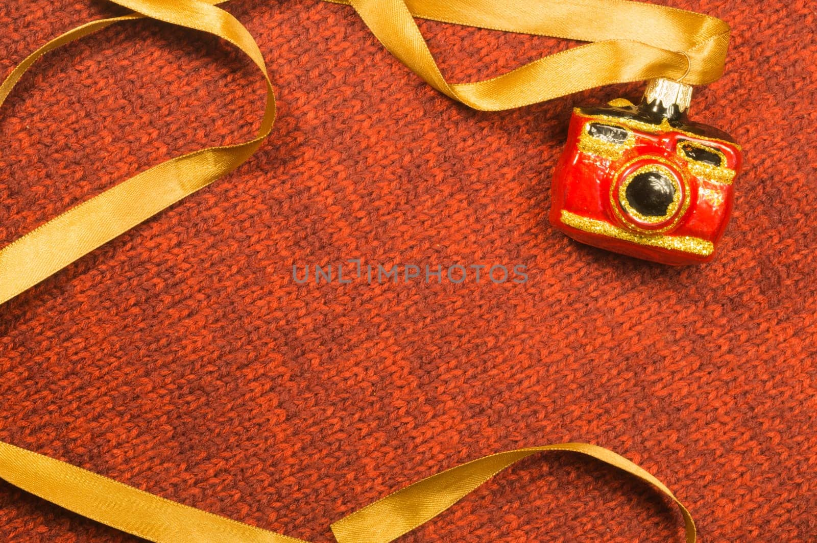 Christmas tree decoration on textile background. Christmas tree toy in a form of a camera. copy space