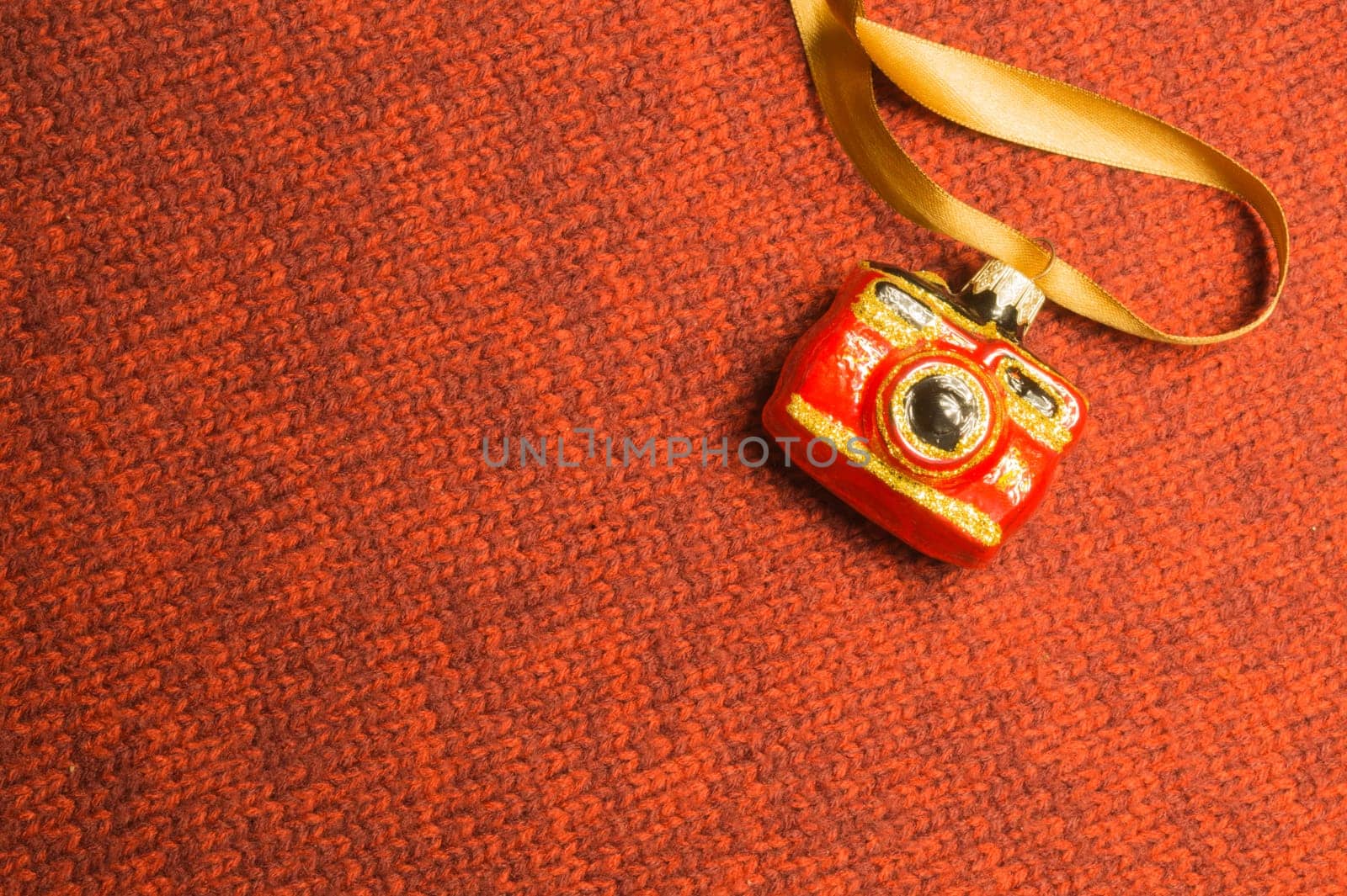 Christmas tree decoration on textile background. Christmas tree toy in a form of a camera. copy space