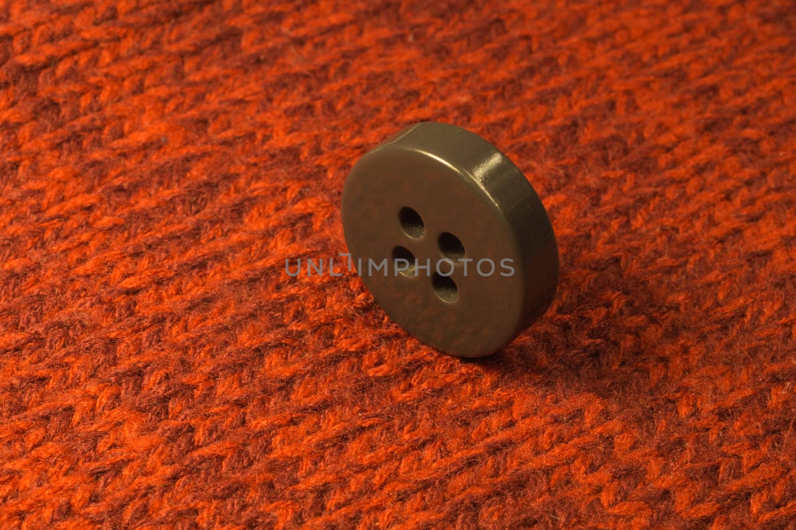 Button on red textile background. macro view. copy space