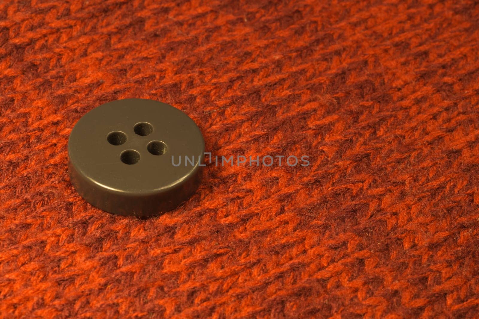 Button on red textile background. macro view. copy space
