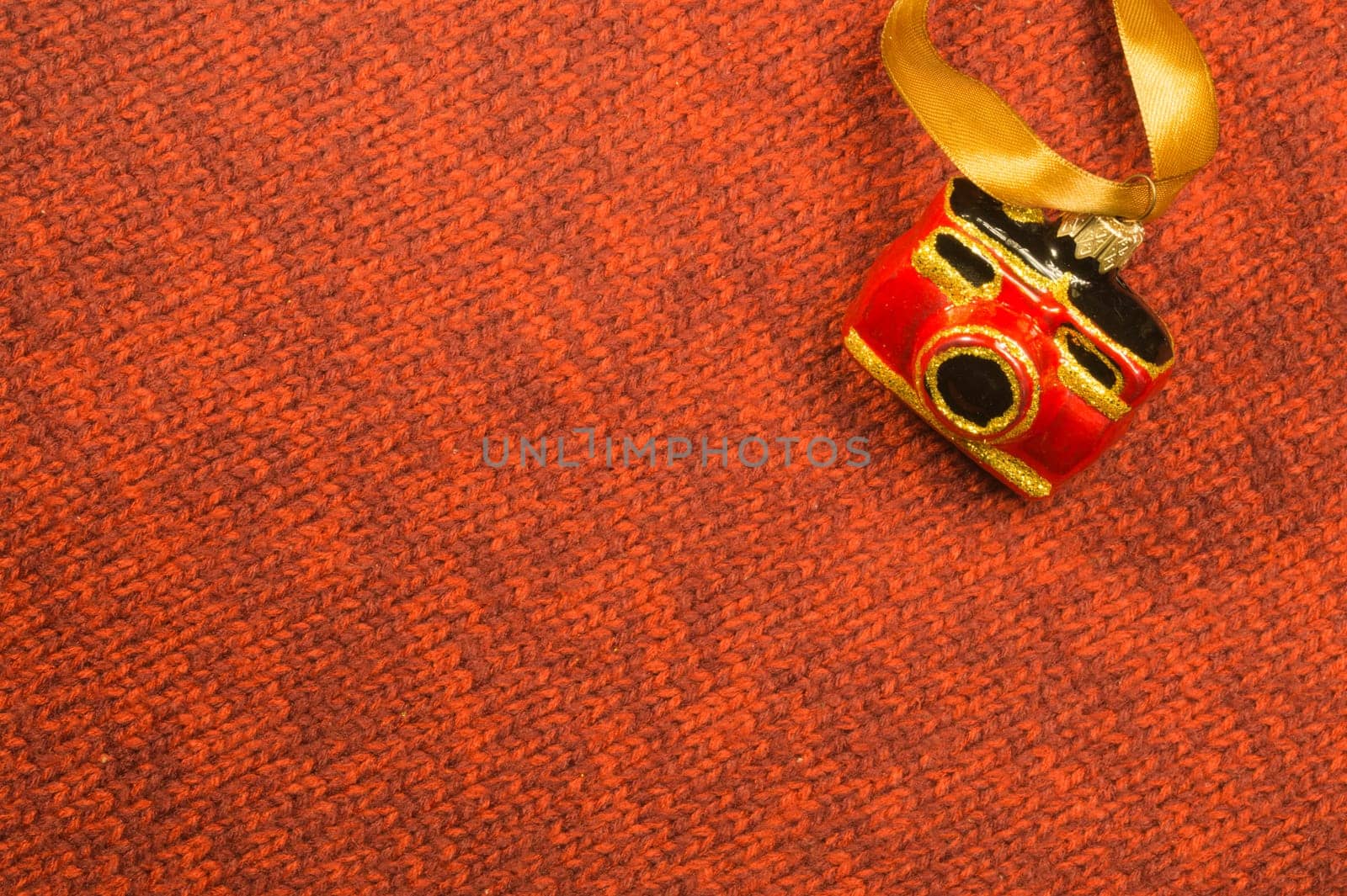 Christmas tree decoration on textile background. Christmas tree toy in a form of a camera. copy space