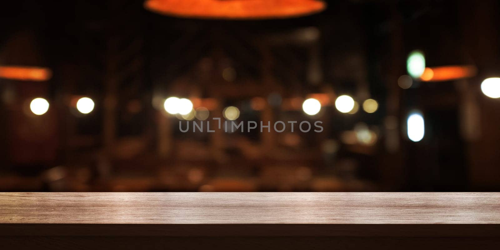 Empty wooden table top with blur coffee shop or restaurant interior background, Panoramic banner. Abstract background can be used for display or montage your products.