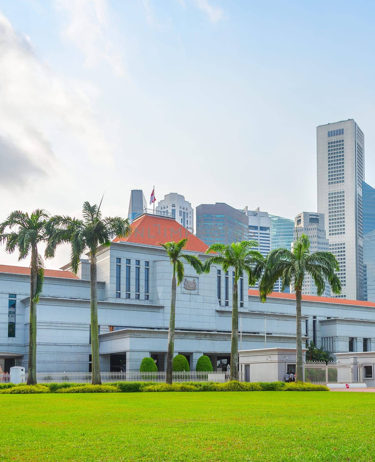 Singapore government building by green lawn, modern cityscape in background