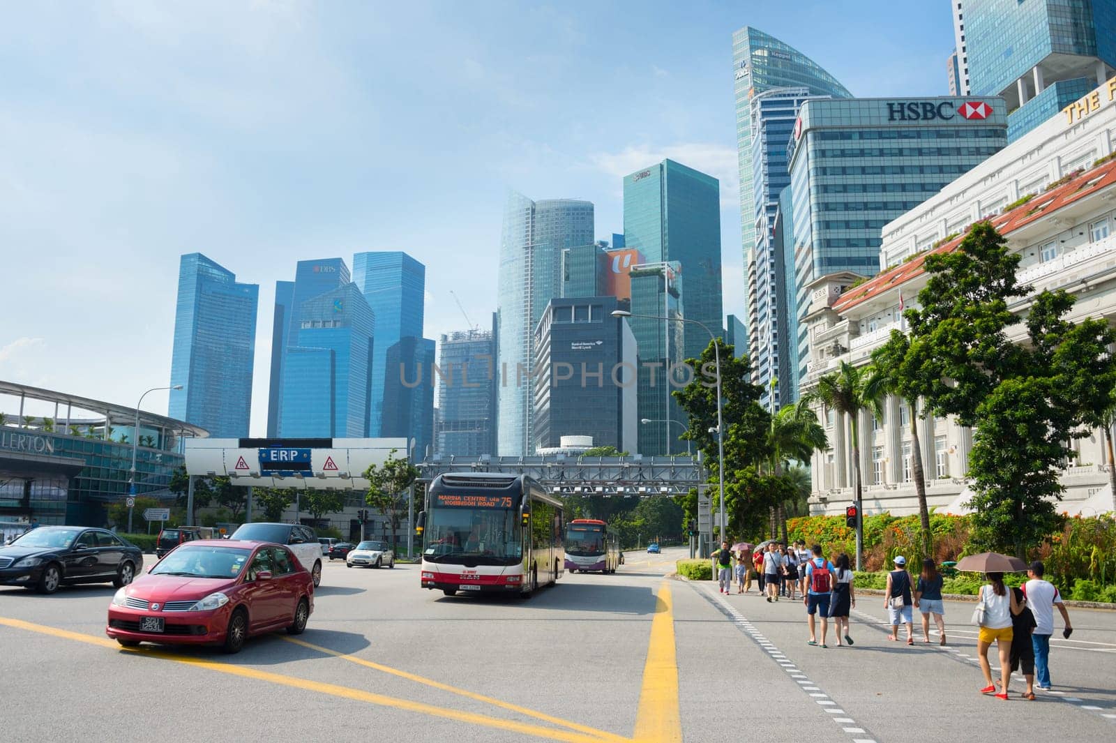 People at crosswalk, cars traffic, cityscape with Singapore downtown Core in sunshine