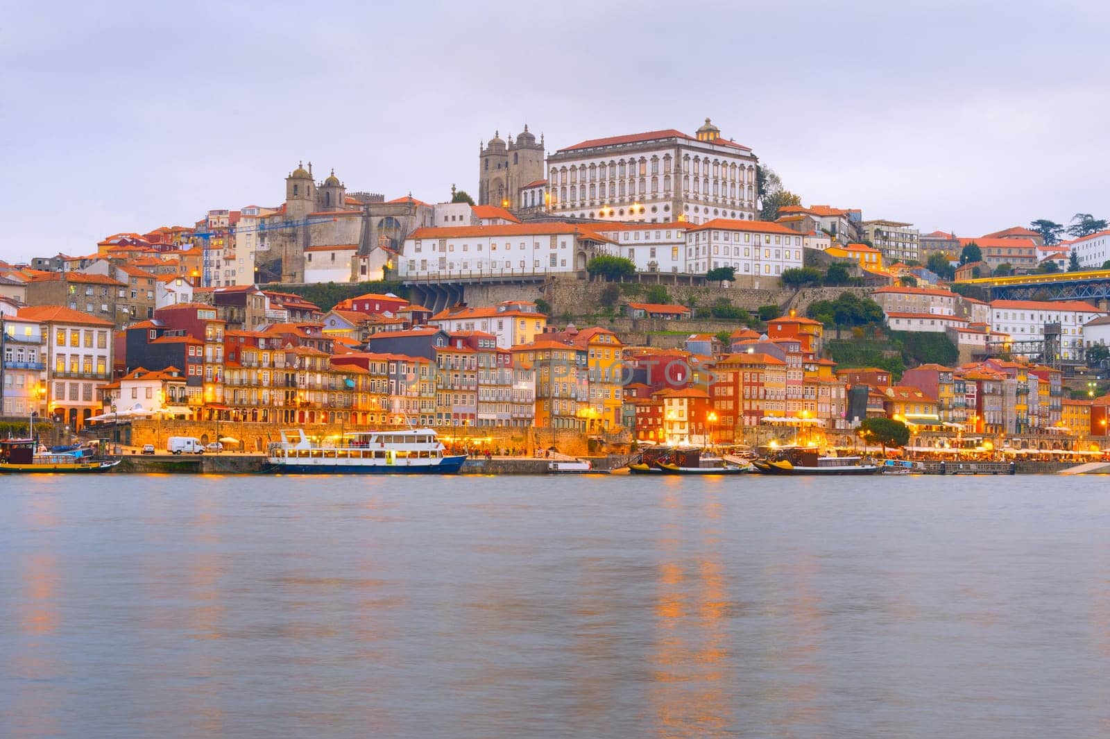 Scenic evening Porto cityscape with Douro embankment and illuminated old town architecture, Portugal